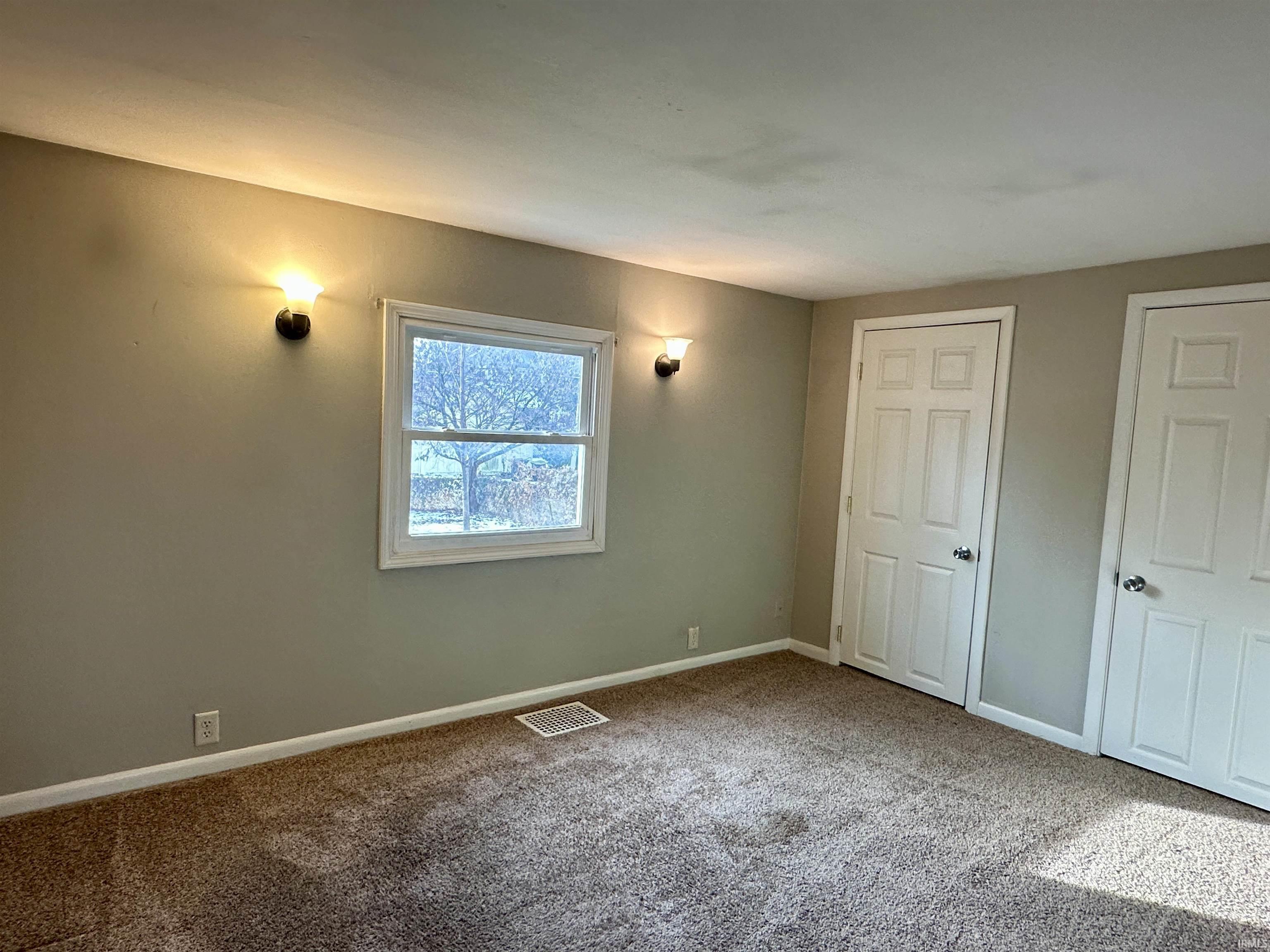 Unfurnished bedroom featuring carpet flooring and baseboards