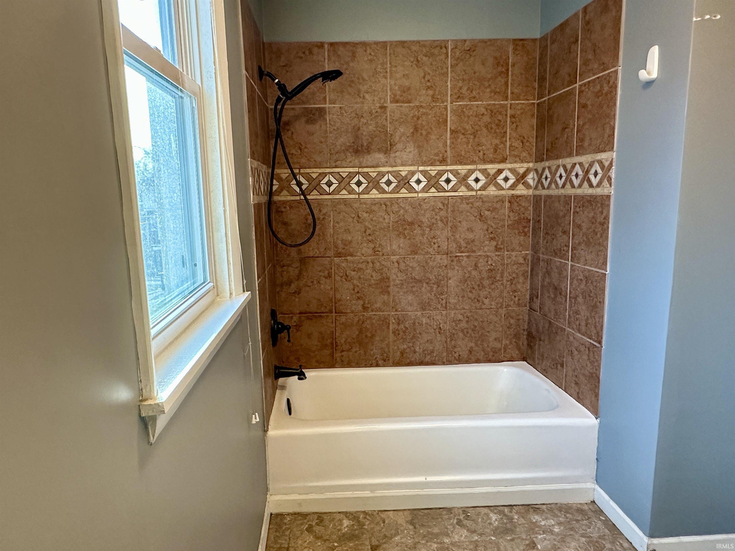 Bathroom with plenty of natural light and shower / tub combination