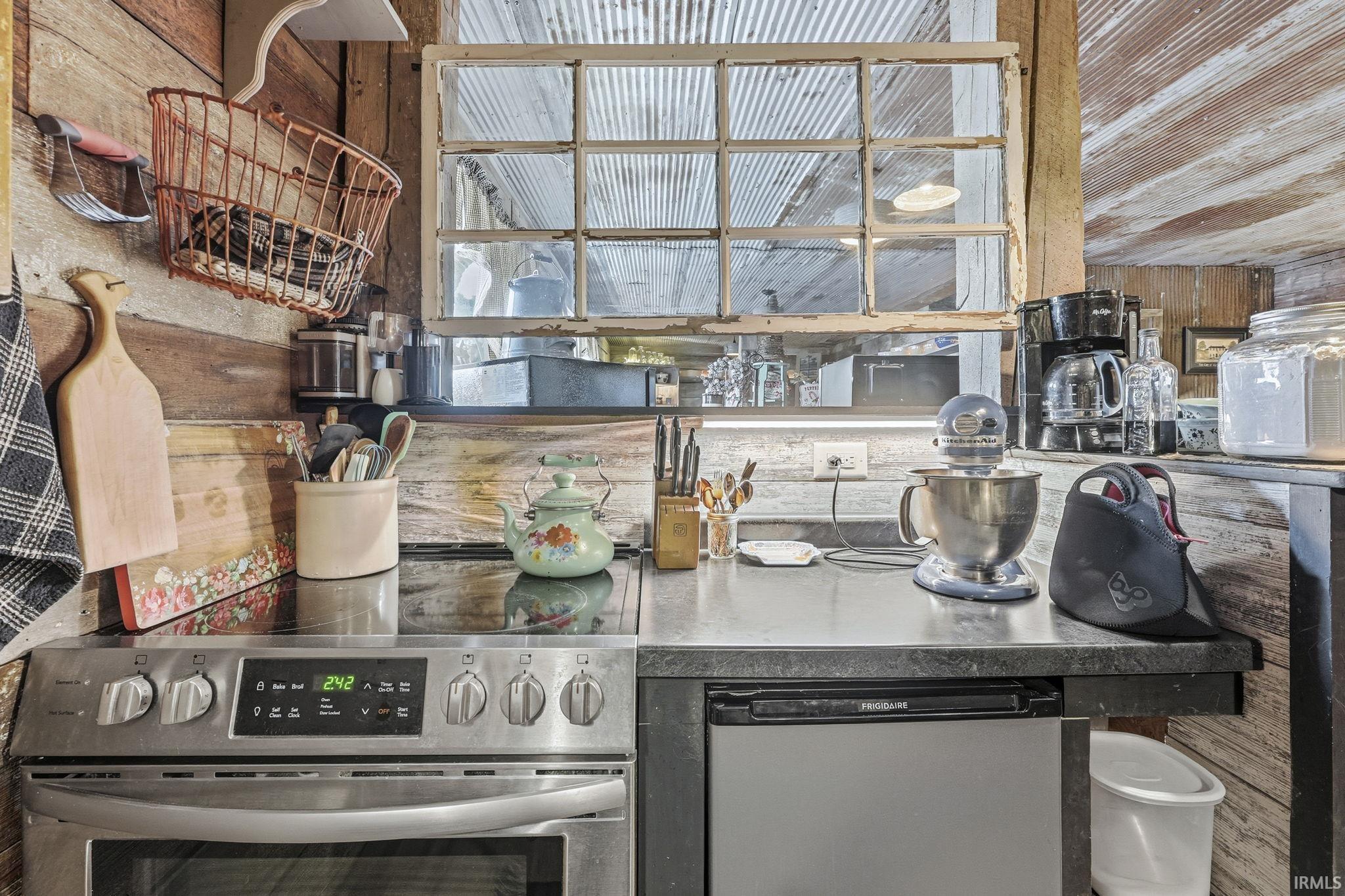 Kitchen with stainless steel appliances and wooden walls