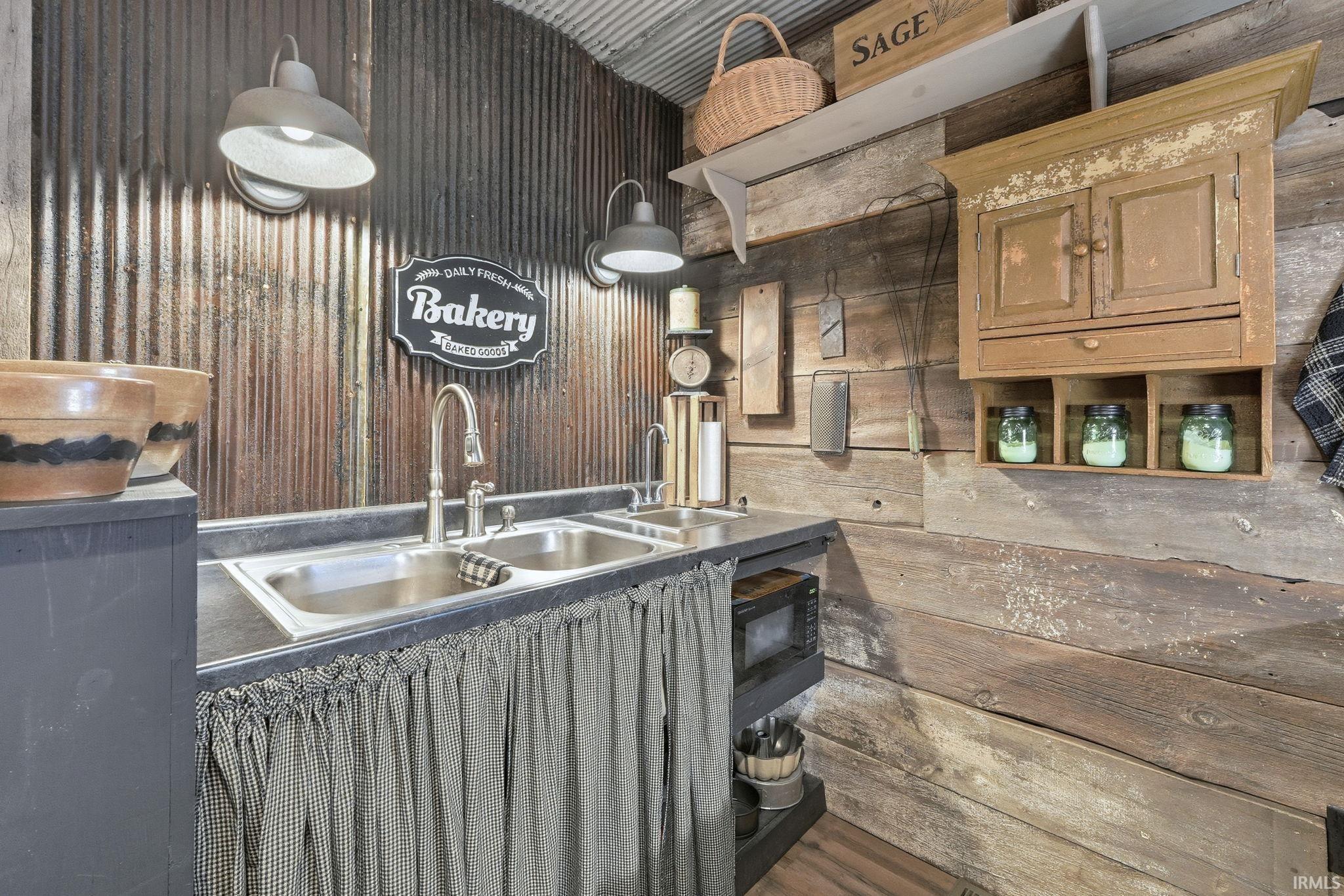 Kitchen with wood walls, black microwave, and dark countertops