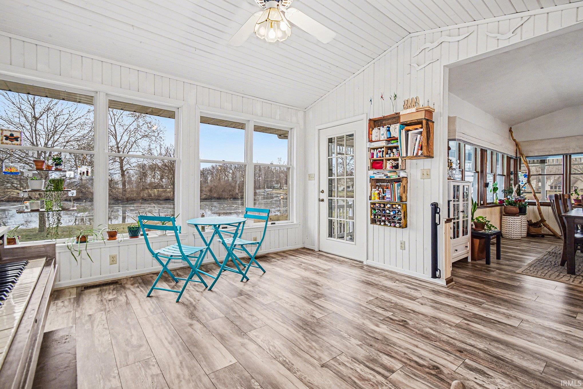 Sunroom with vaulted ceiling, wood finished floors, wood walls, and wood ceiling