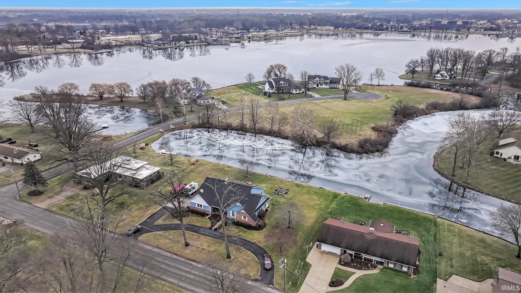 Aerial view of property and surrounding area with a nearby body of water