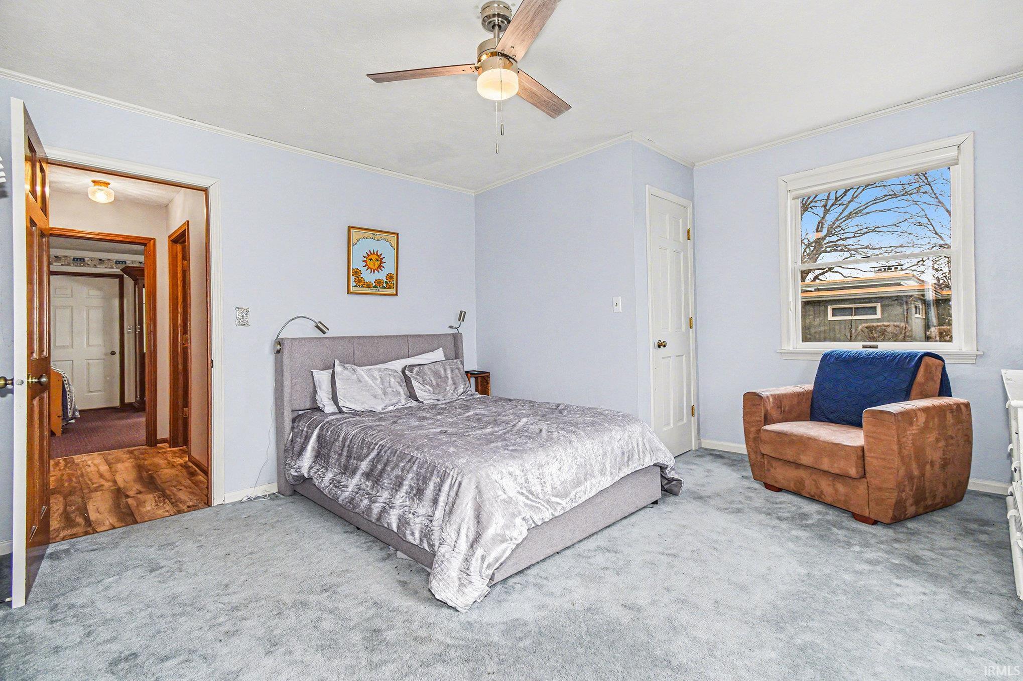 Bedroom featuring carpet floors, a ceiling fan, and ornamental molding