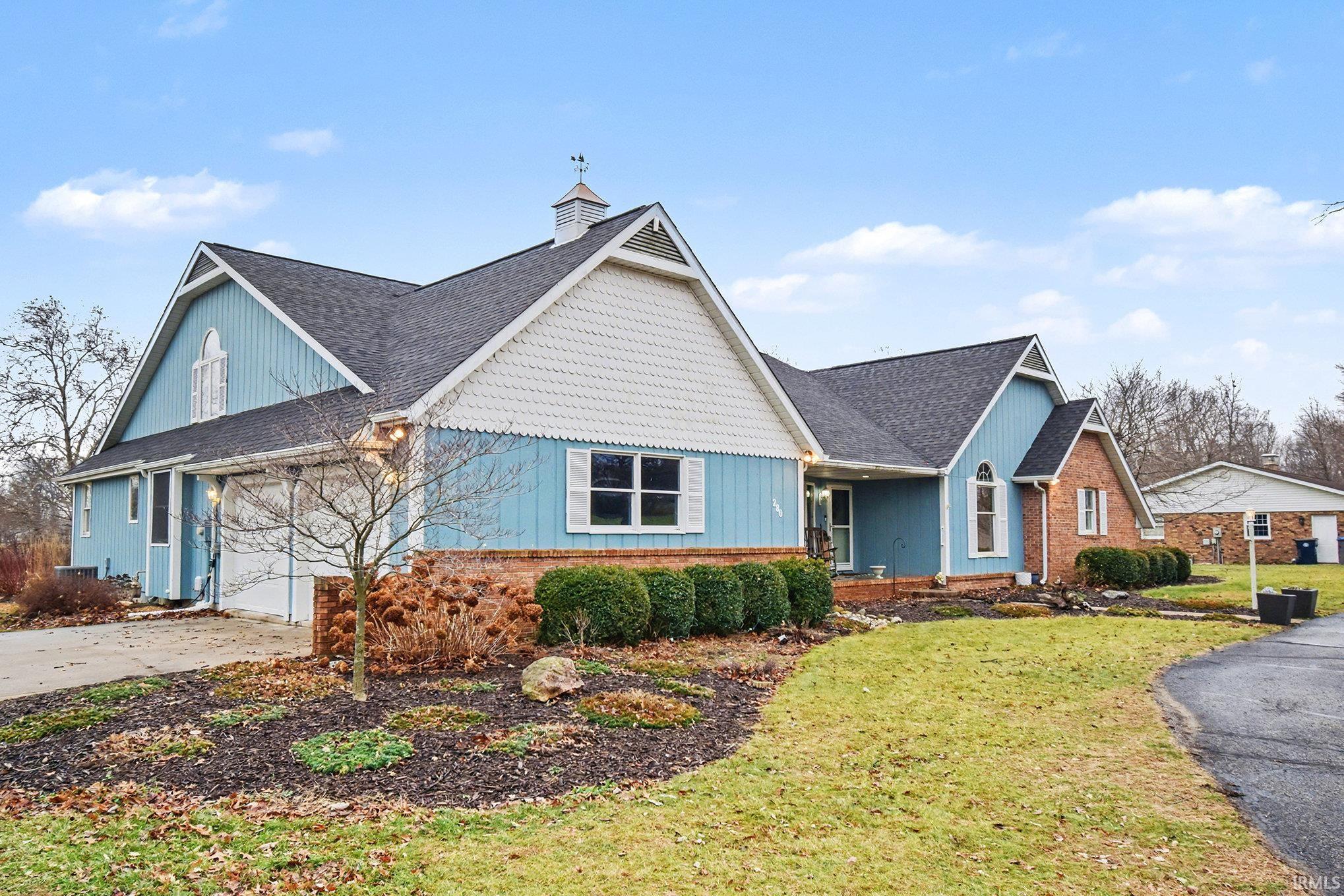 View of front of property with a front yard, concrete driveway, a garage, and board and batten siding