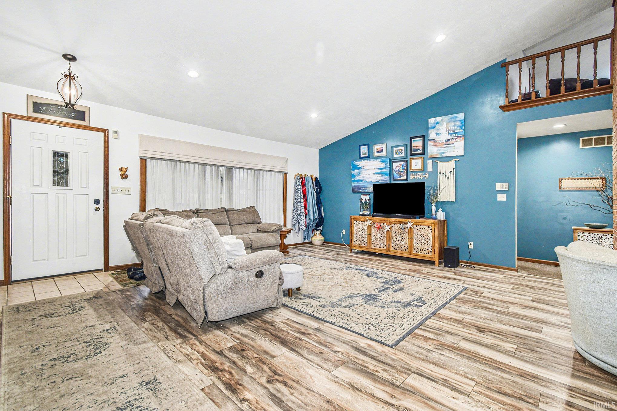 Living room featuring recessed lighting, light wood-style floors, and high vaulted ceiling