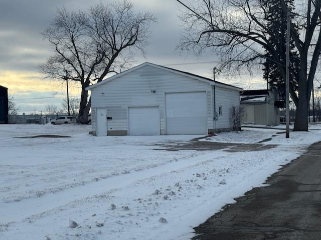 Snow covered garage featuring a garage