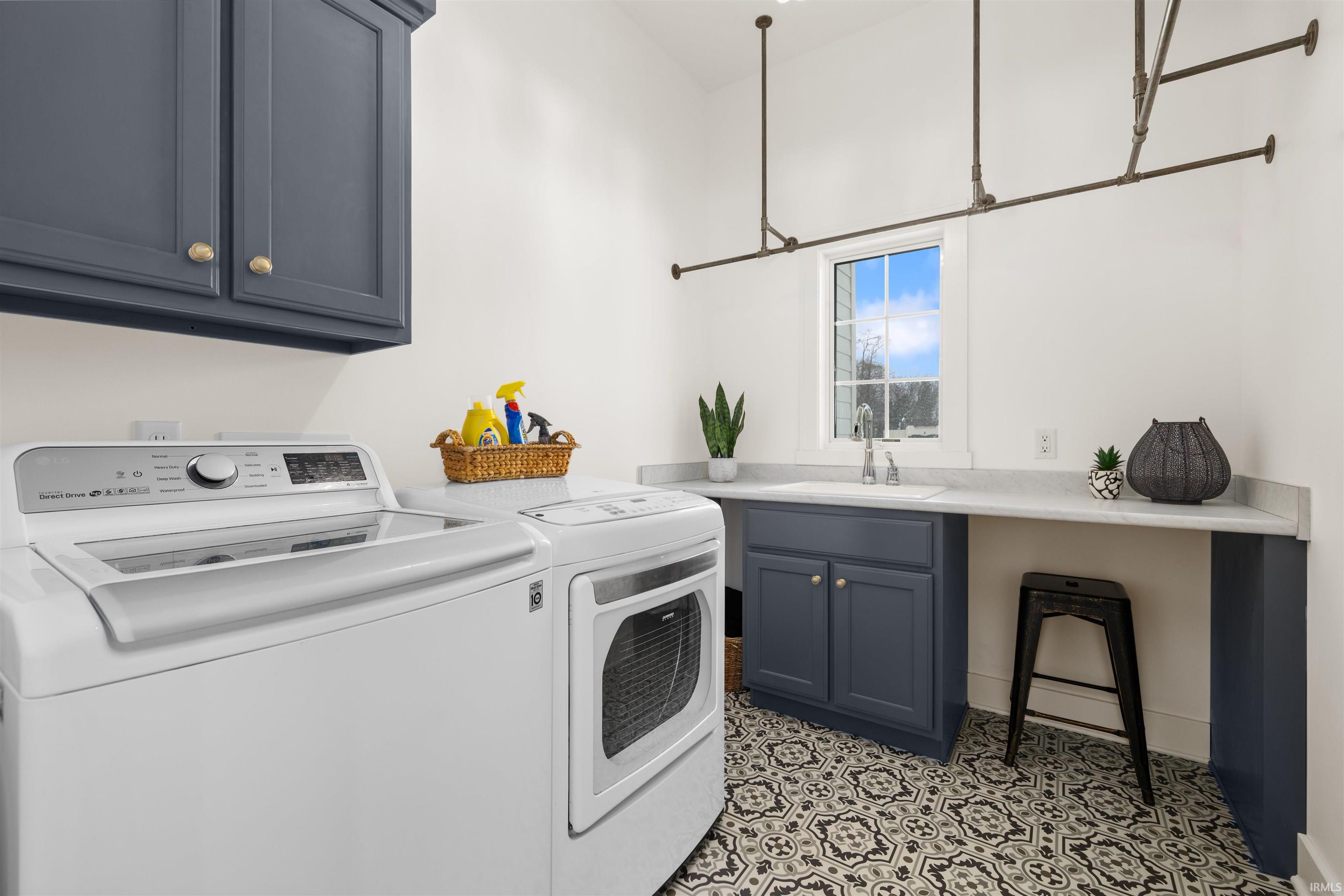 Laundry area featuring independent washer and dryer and cabinet space