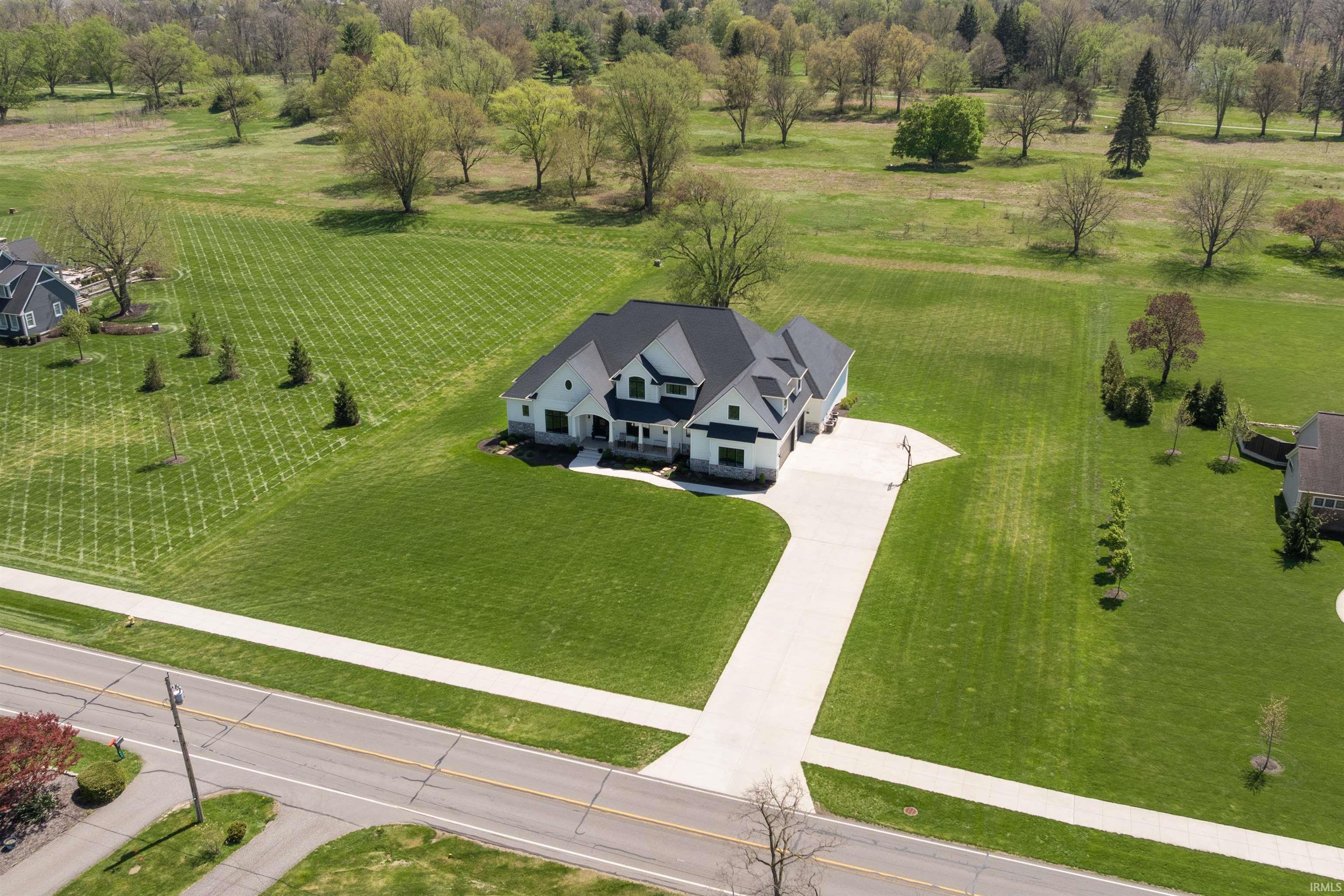 Modern farmhouse exterior with a dark shingle roof, white siding, and black window trim