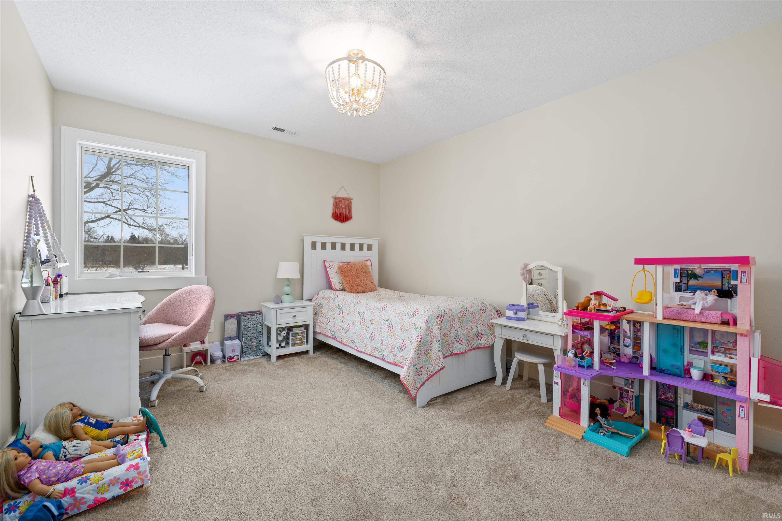 Bedroom featuring light colored carpet and a chandelier