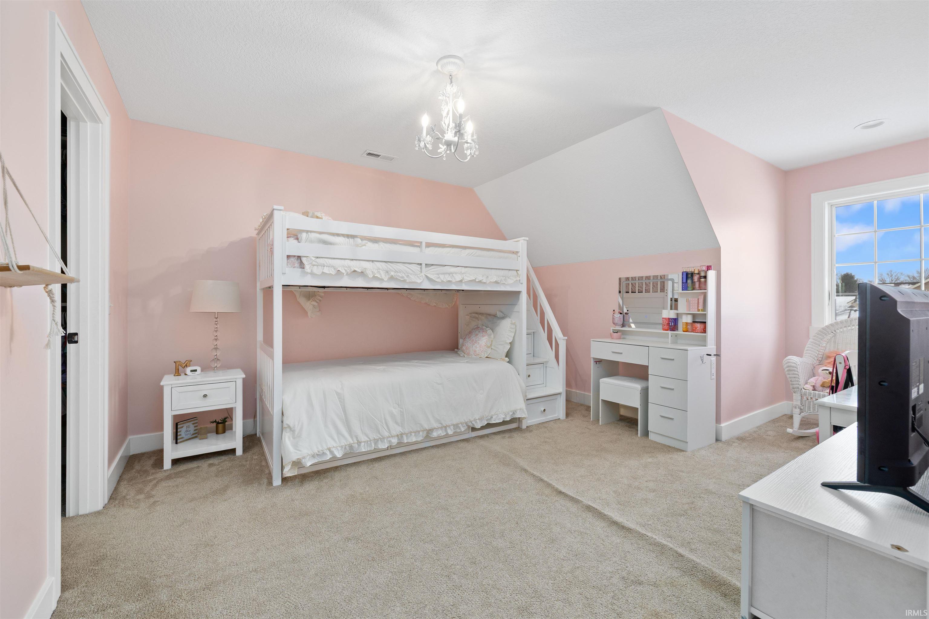 Bedroom featuring light carpet and vaulted ceiling