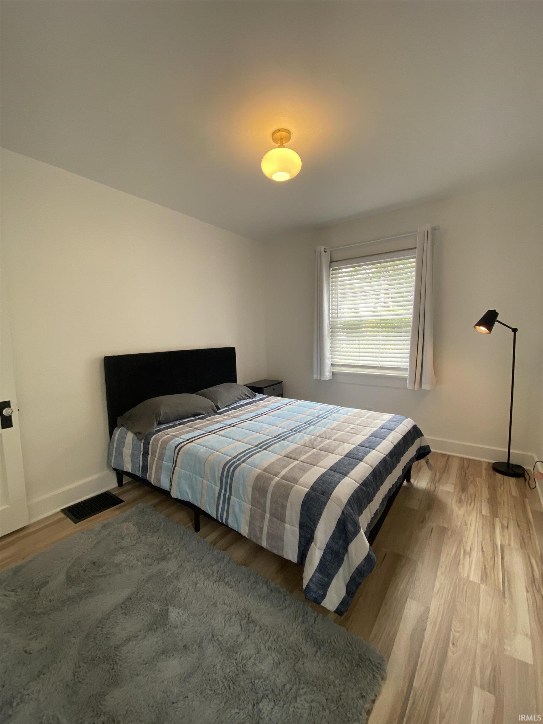 Bedroom with light wood-style floors and baseboards