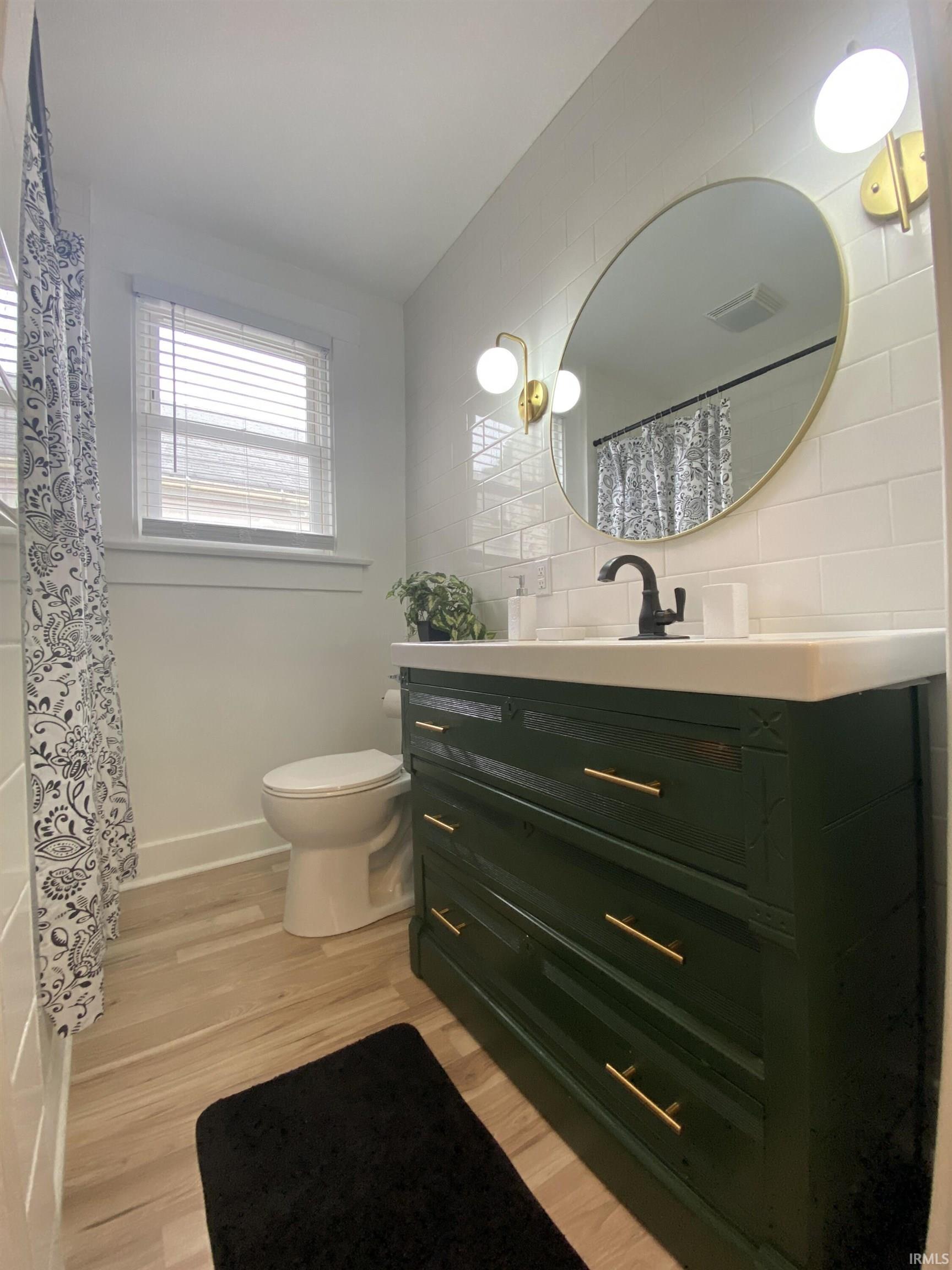 Bathroom with light wood-type flooring, vanity, and a shower with curtain