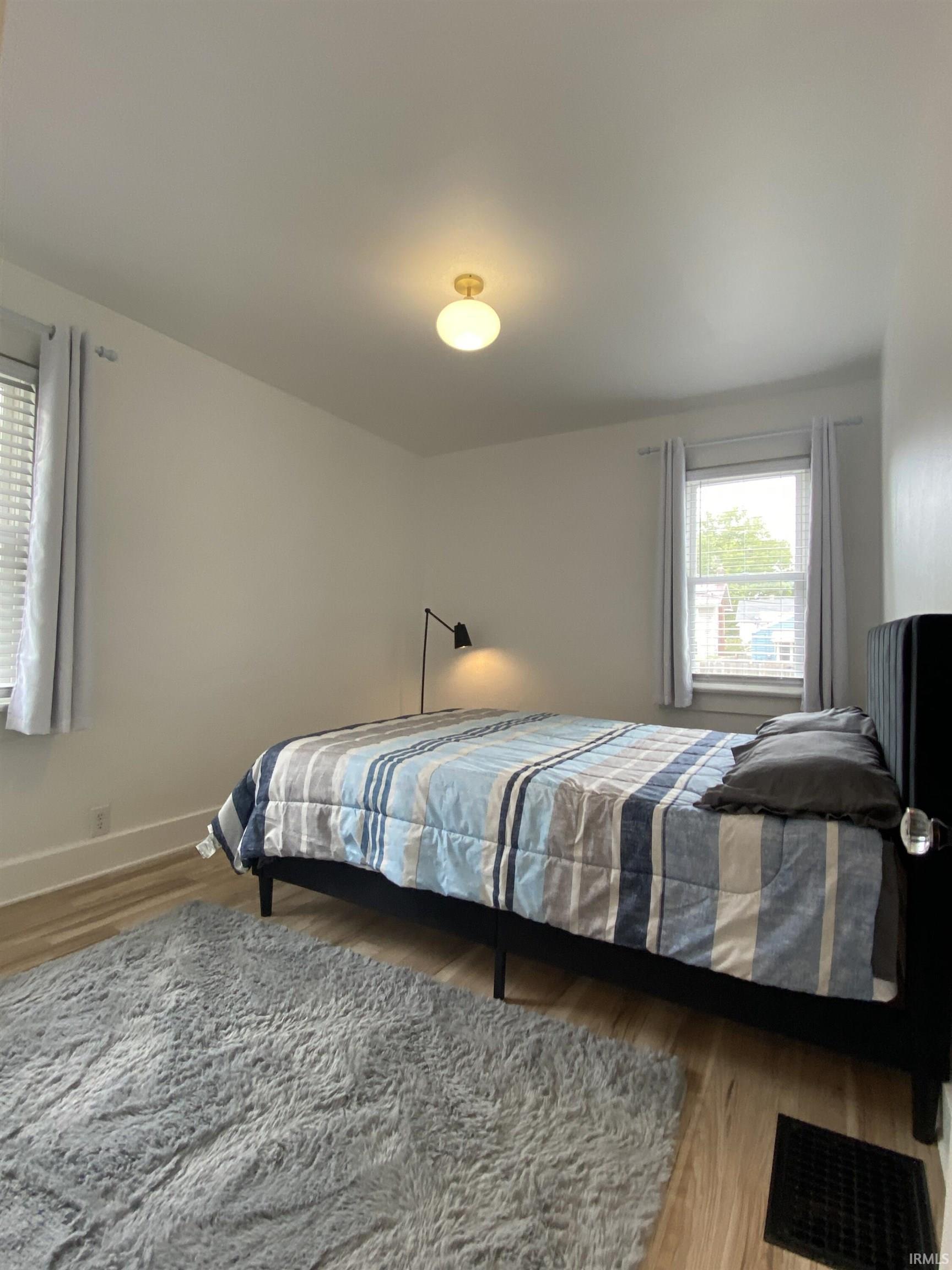 Bedroom with light wood-type flooring and baseboards