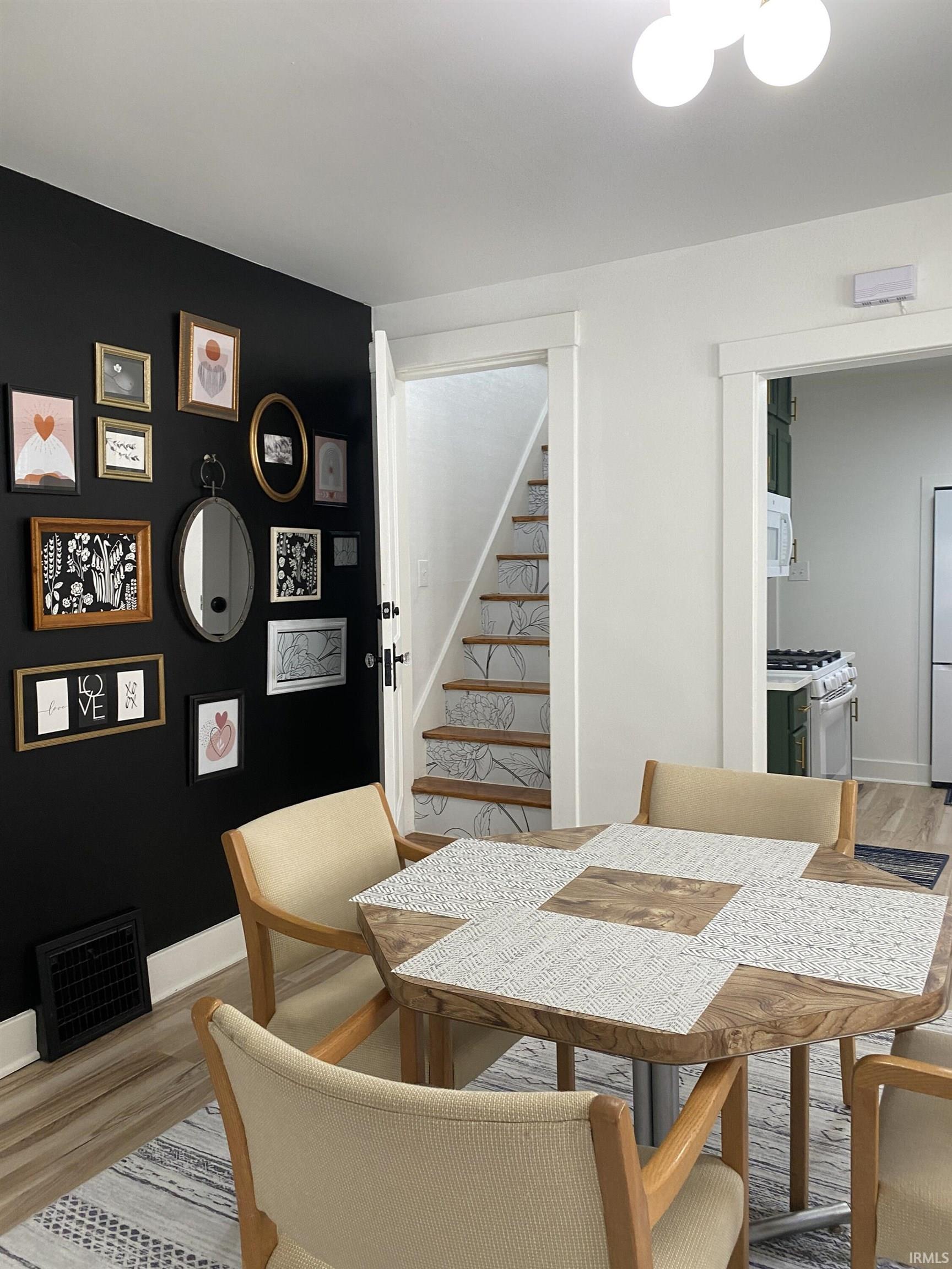 Dining area with light wood finished floors and stairway