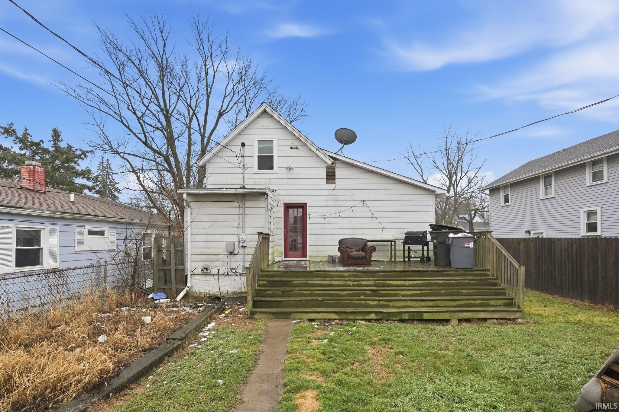 Back of house with a fenced backyard and a wooden deck