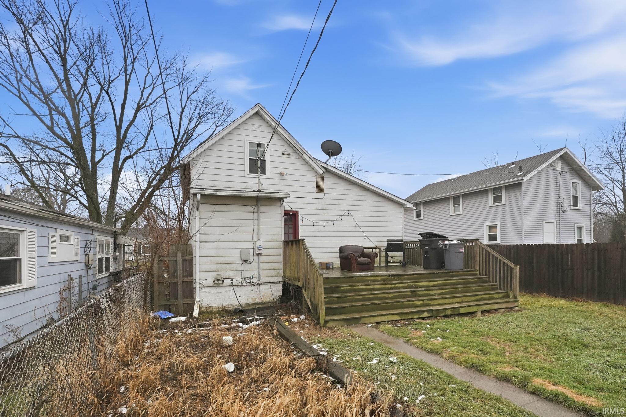 Rear view of property with a deck and a fenced backyard