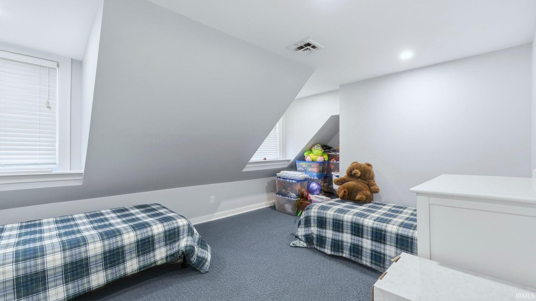 Bedroom featuring dark carpet and baseboards
