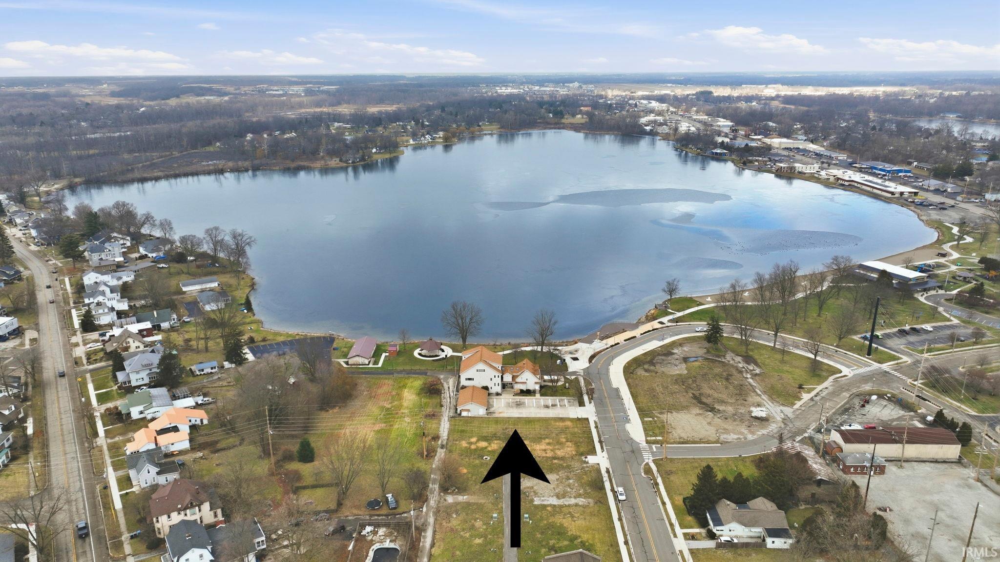 Aerial view of property's location featuring a large body of water and nearby suburban area
