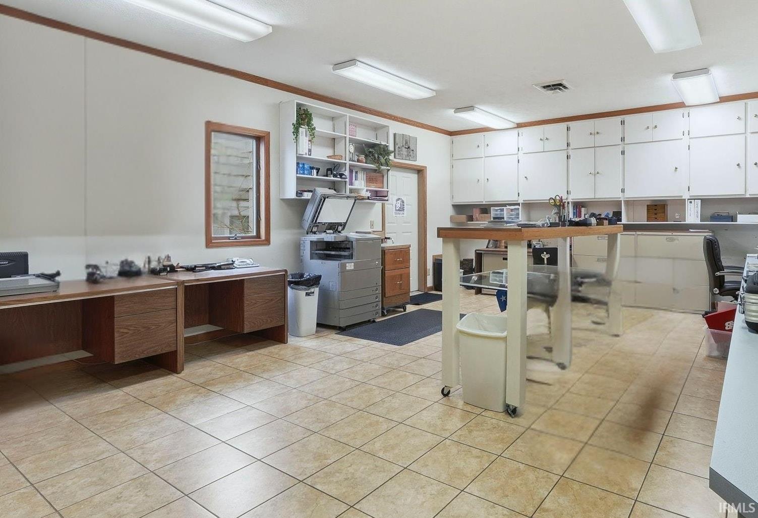 Kitchen with a desk, white cabinetry, and open shelves
