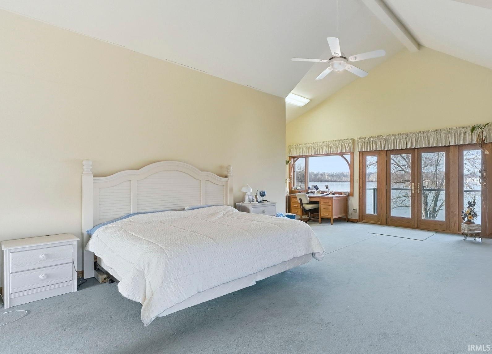 Carpeted bedroom with beamed ceiling, high vaulted ceiling, access to outside, a ceiling fan, and french doors