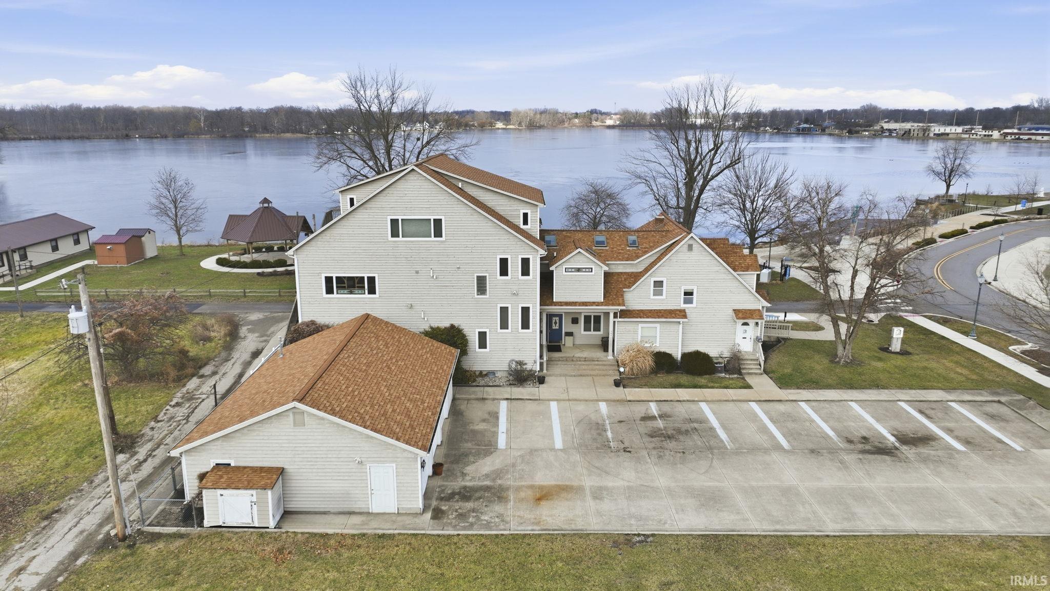Back of property with a water view and a lawn