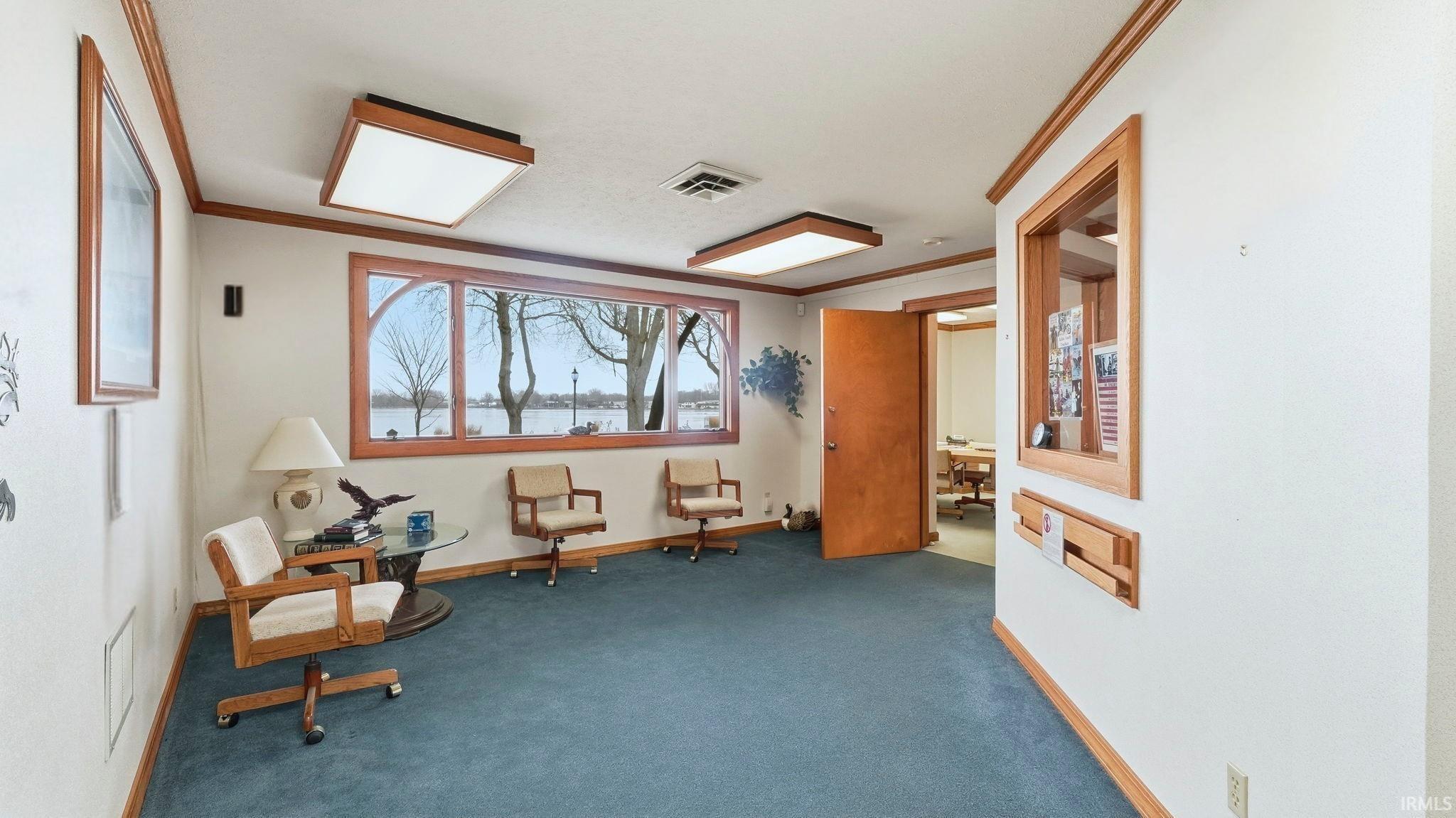 Living area featuring crown molding and carpet floors