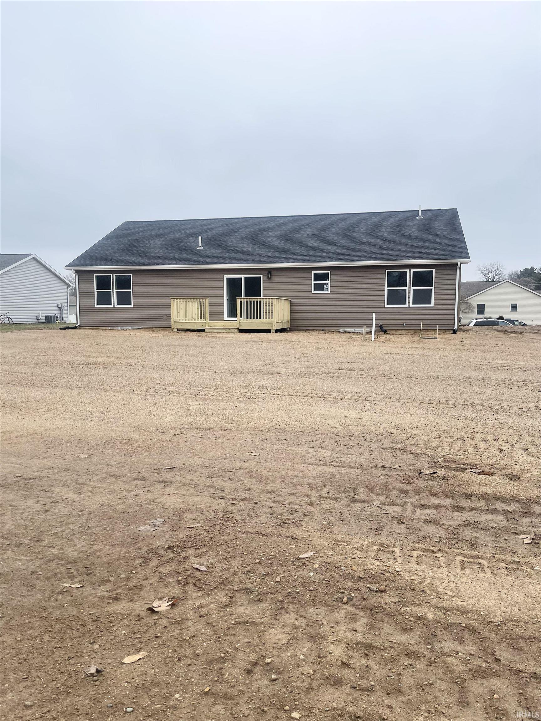 Back of property featuring a deck and roof with shingles