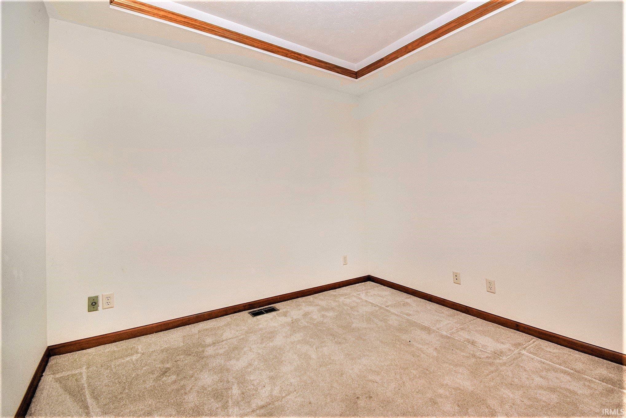 Spare room featuring baseboards and carpet flooring