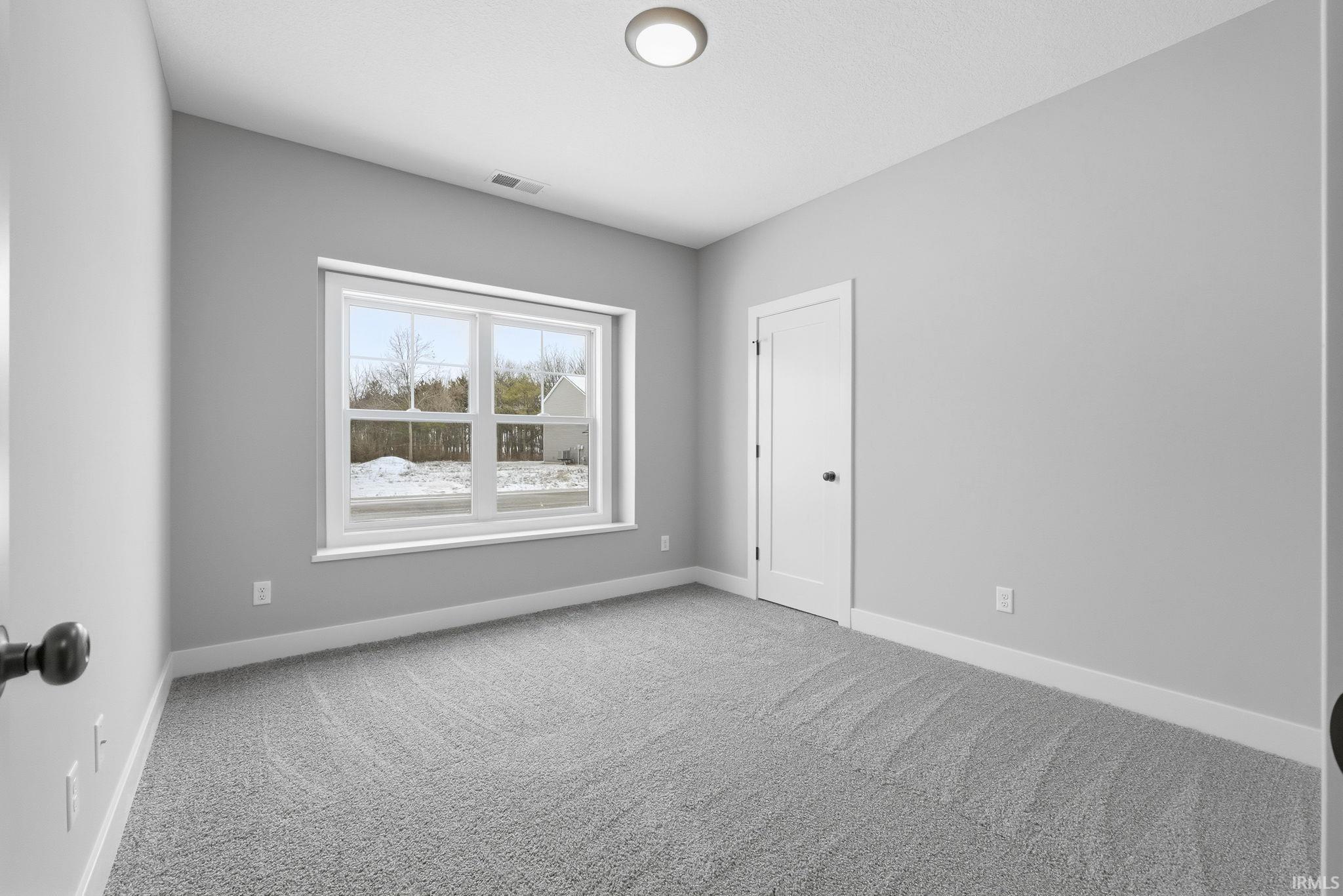 Carpeted empty room featuring baseboards