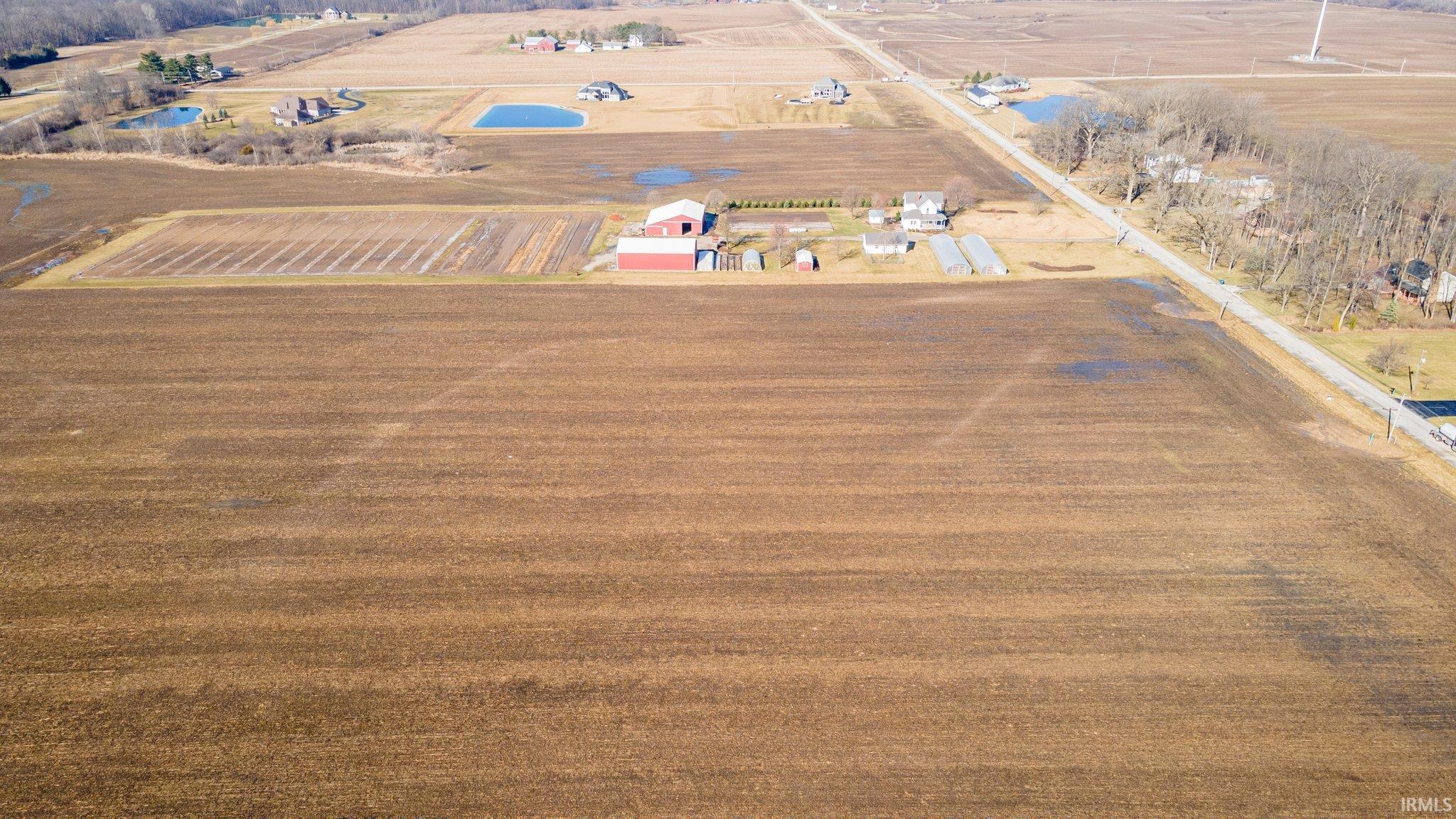 Aerial view of property and surrounding area featuring rural landscape and large plots for crops