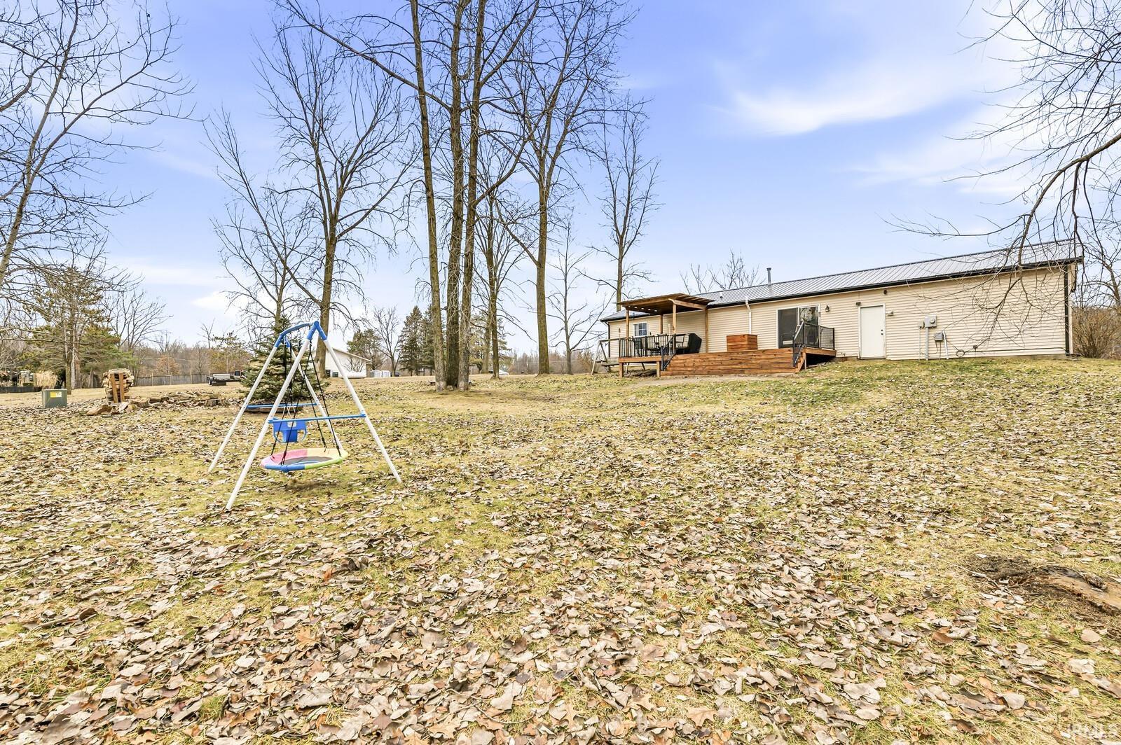 View of yard with a playground and a wooden deck
