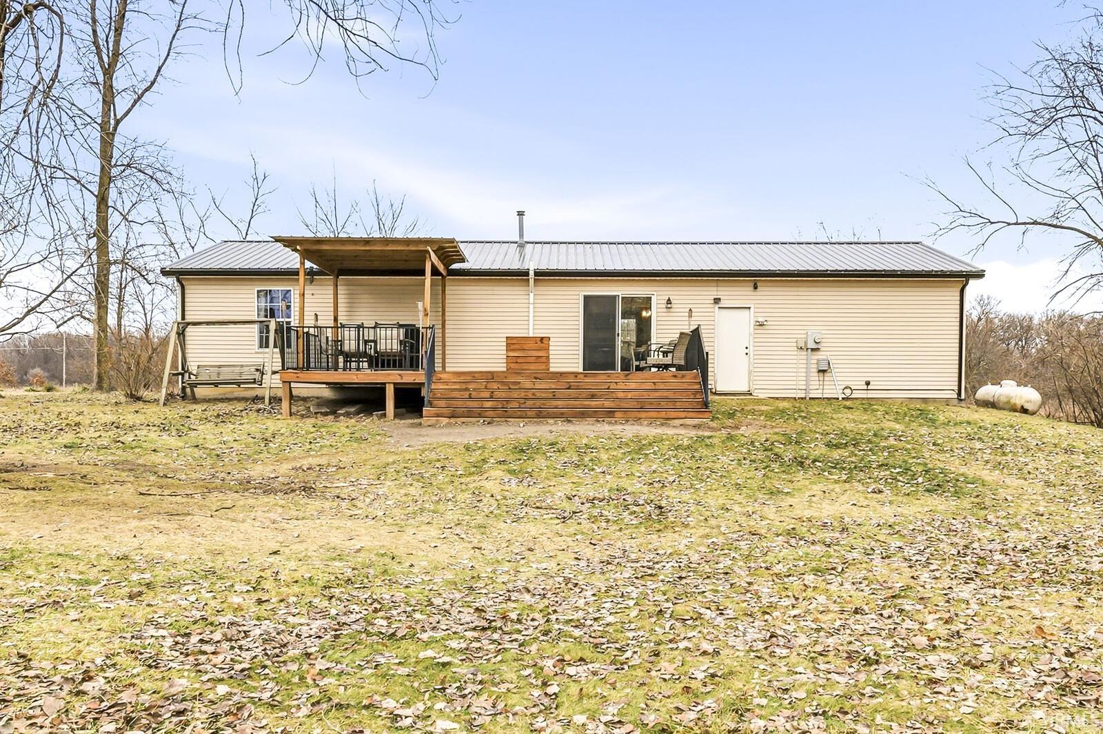 Back of property with a wooden deck and a metal roof