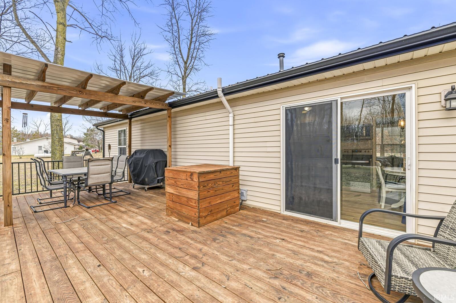 Wooden terrace with outdoor dining area and a grill
