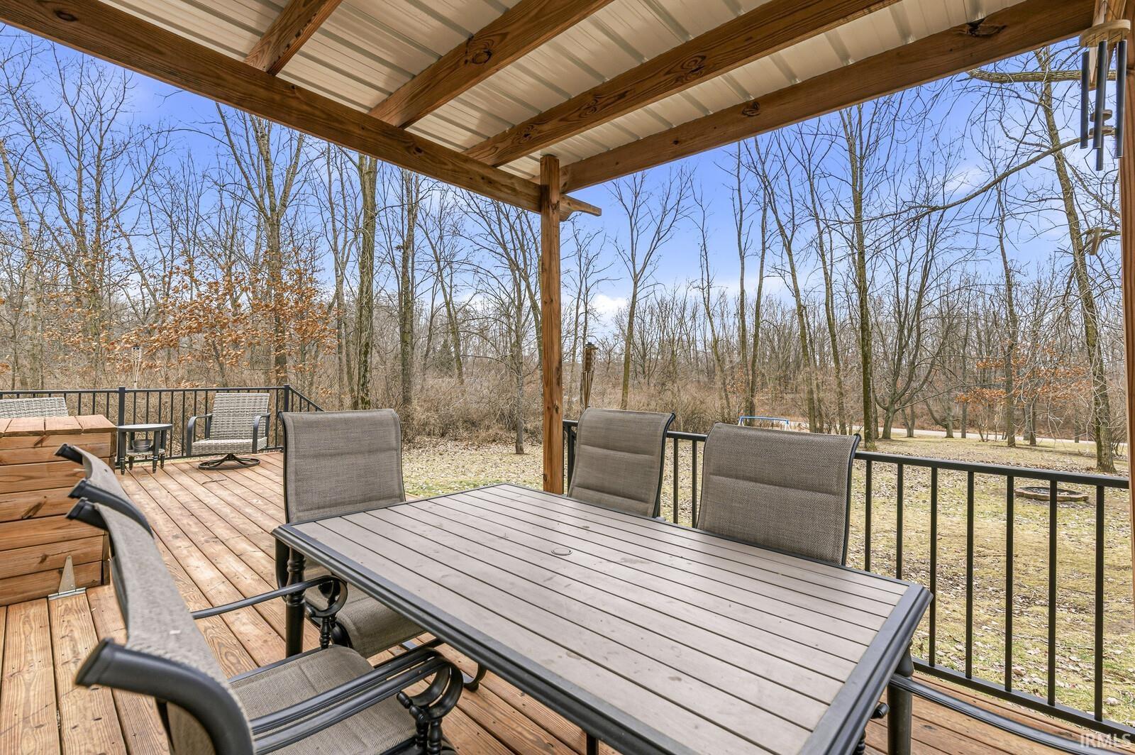 Wooden deck featuring outdoor dining area and view of wooded area