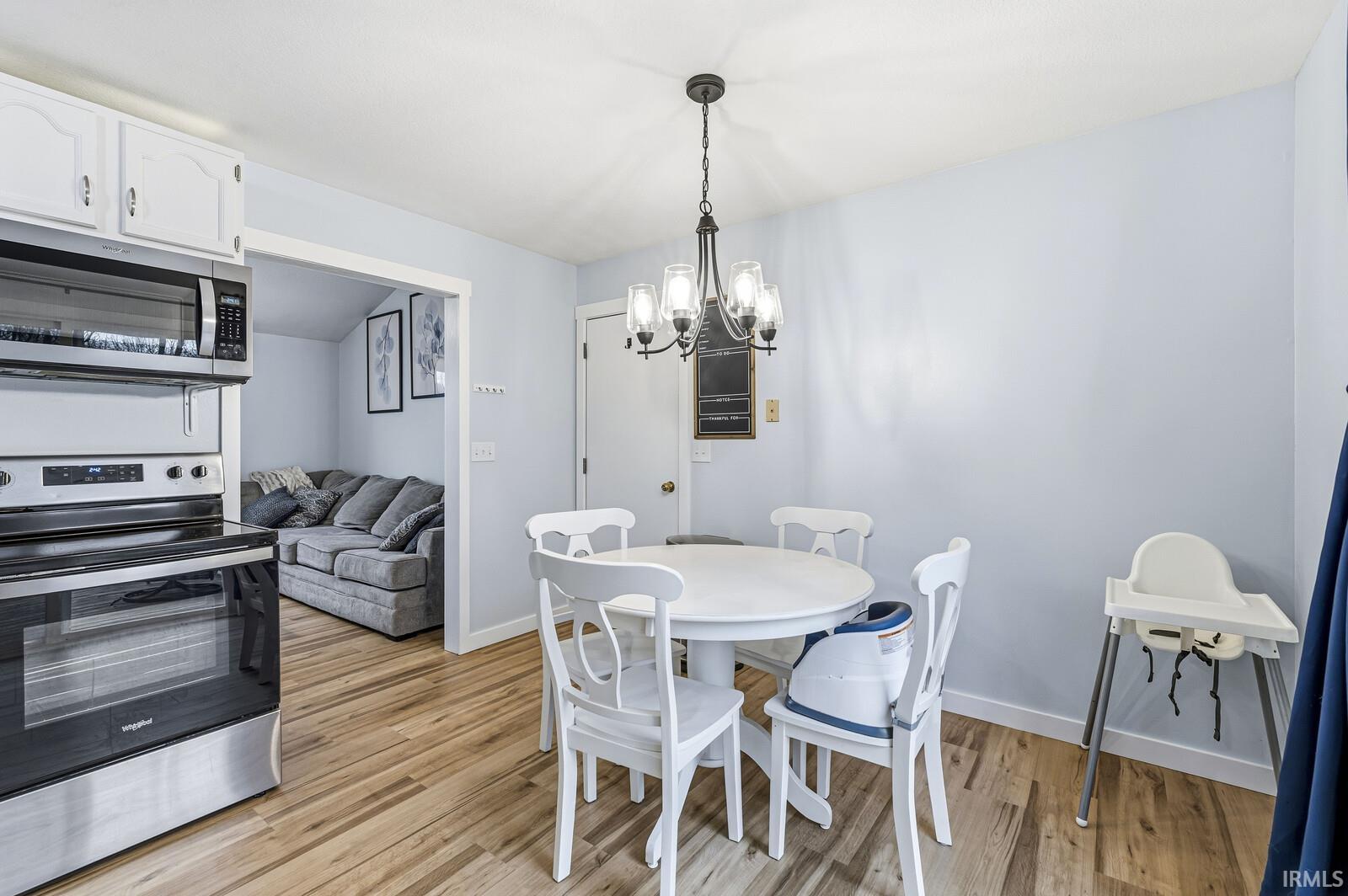 Dining area with a chandelier and light wood-style flooring