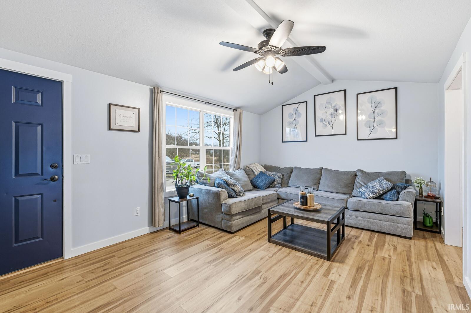 Living area with a ceiling fan and light wood finished floors