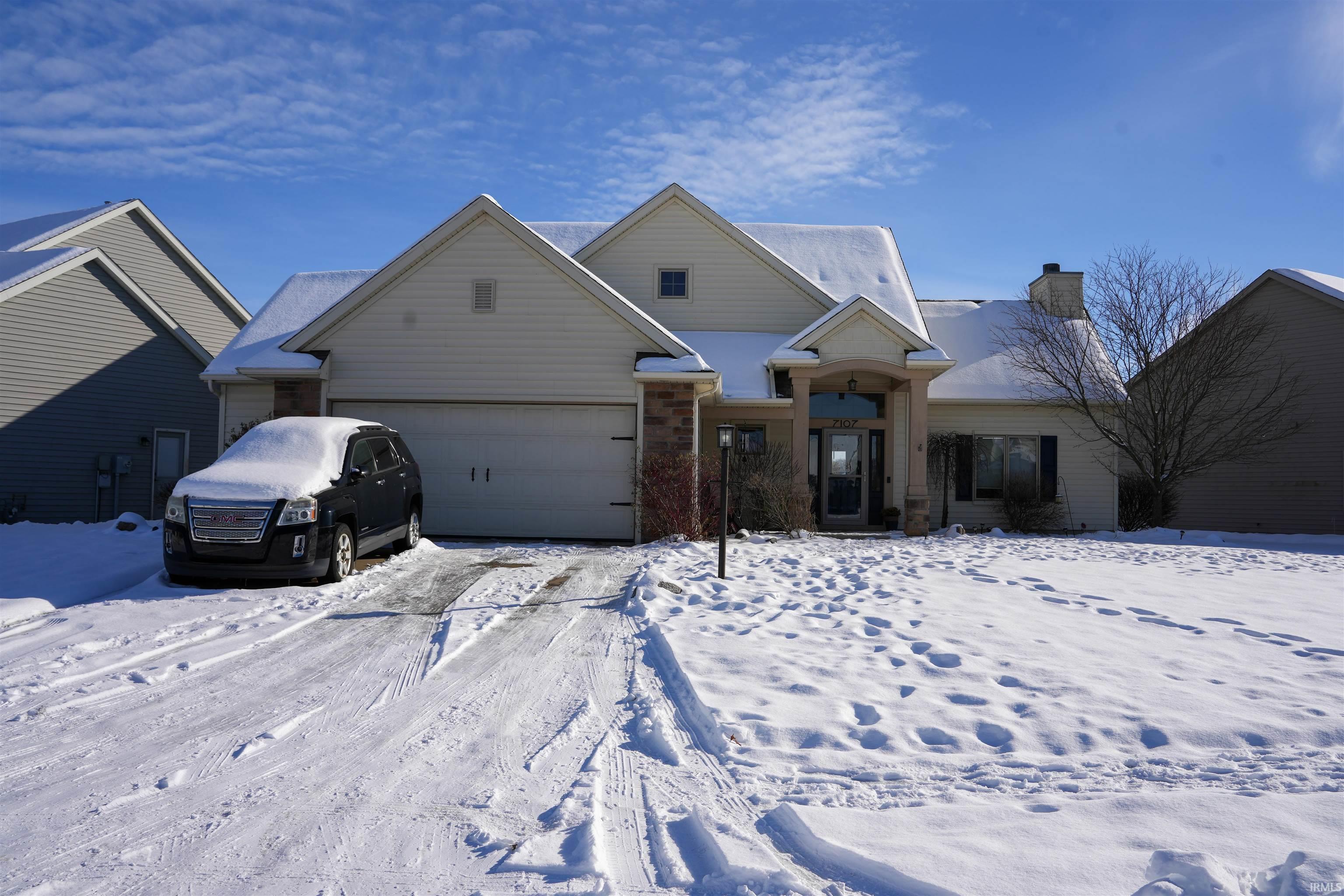 View of front of property with a chimney and an attached garage