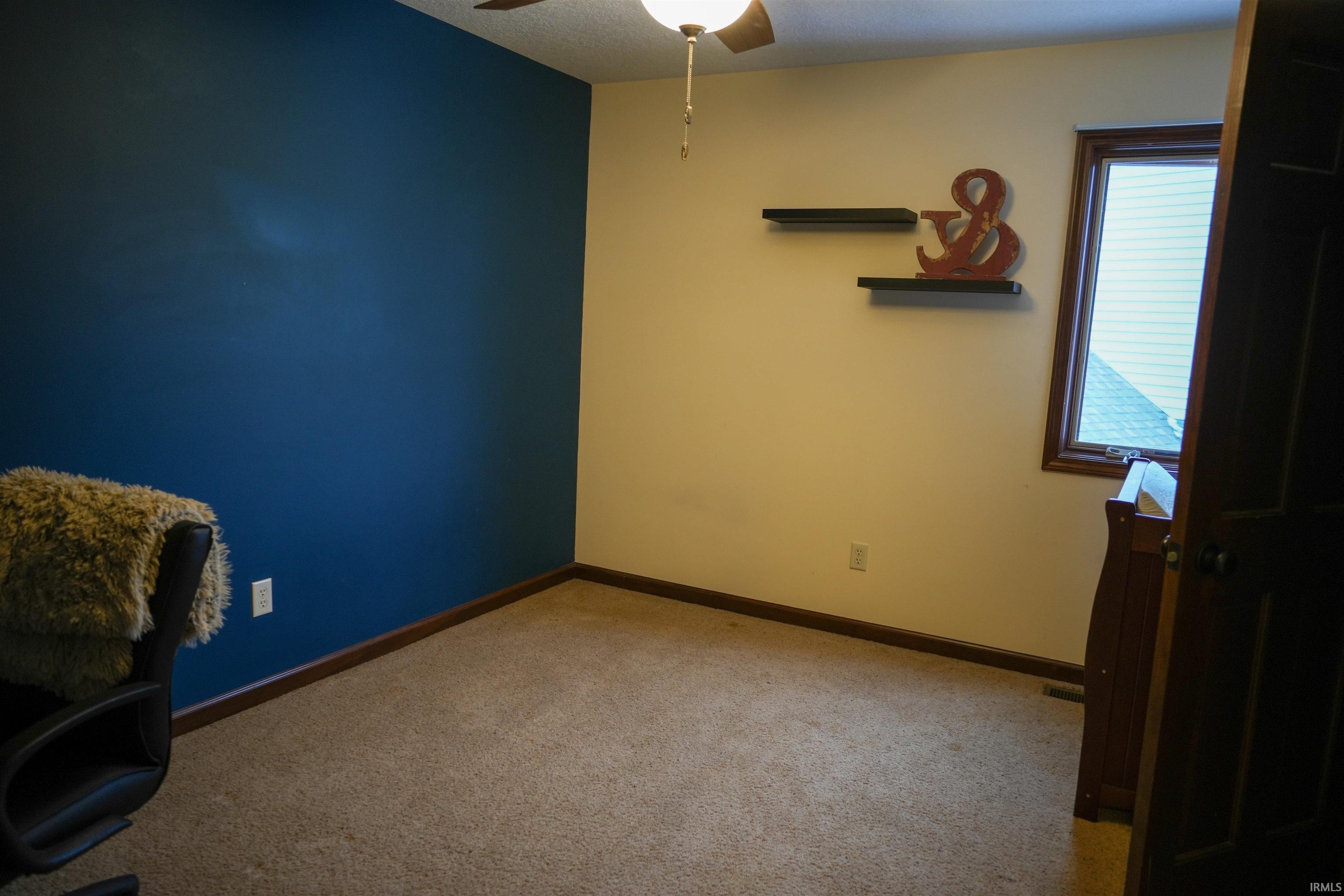 Unfurnished office with a ceiling fan, carpet, and a textured ceiling