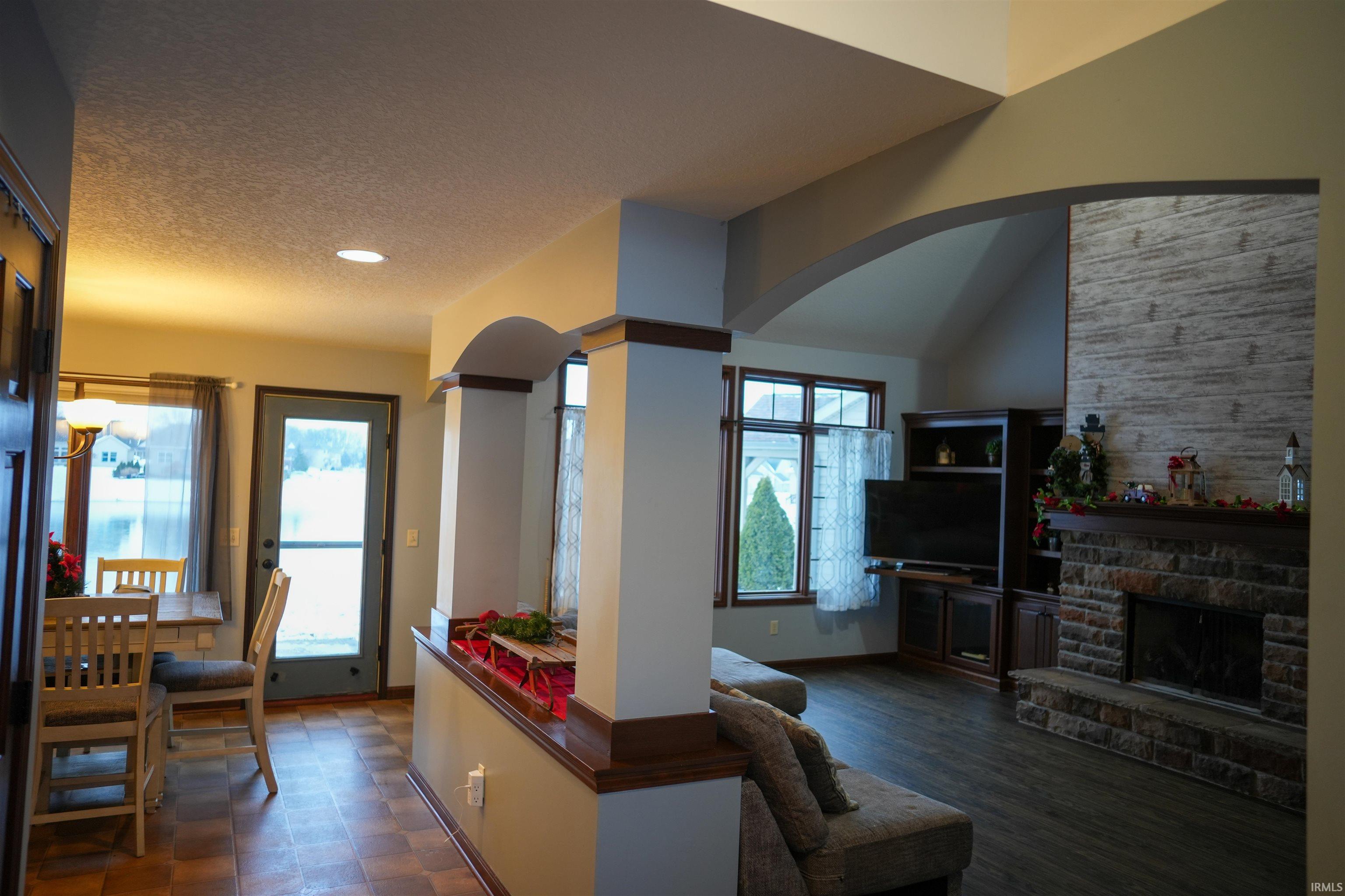 Living room with arched walkways, a textured ceiling, and a fireplace