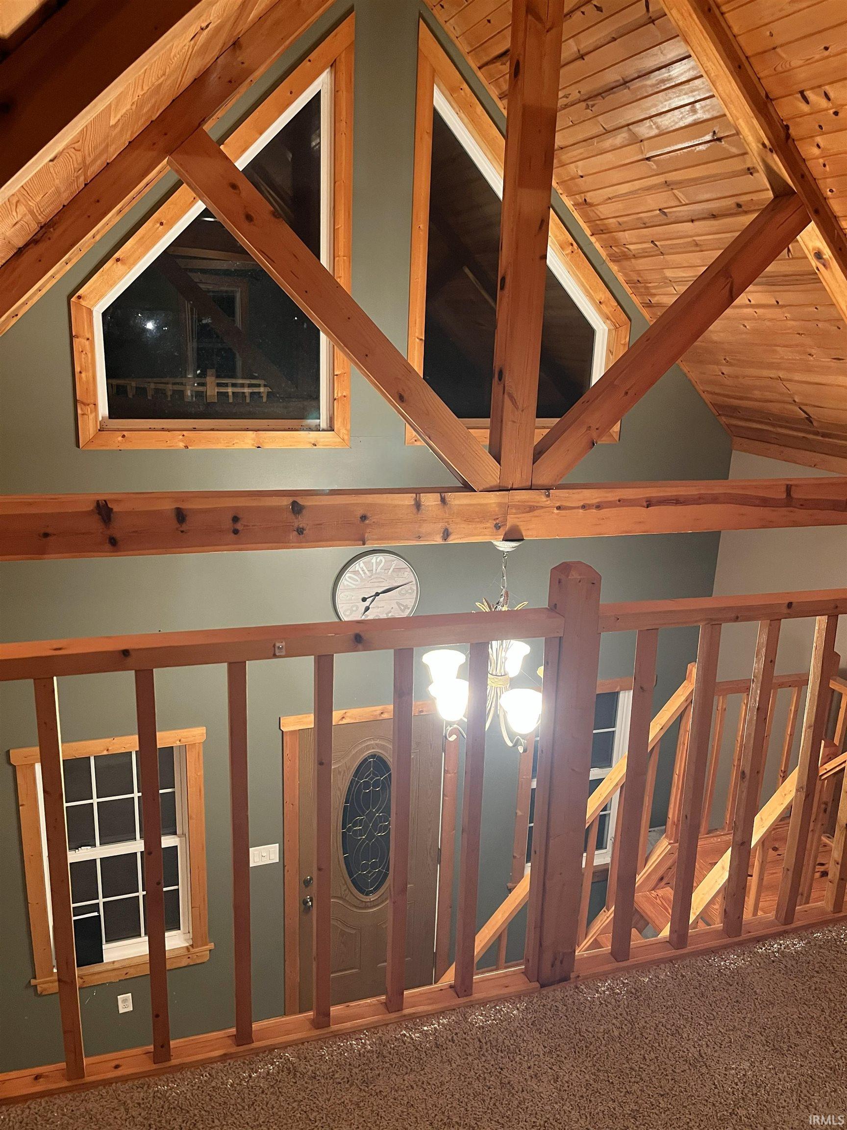 Detailed view of a wood ceiling with exposed beams and carpet flooring