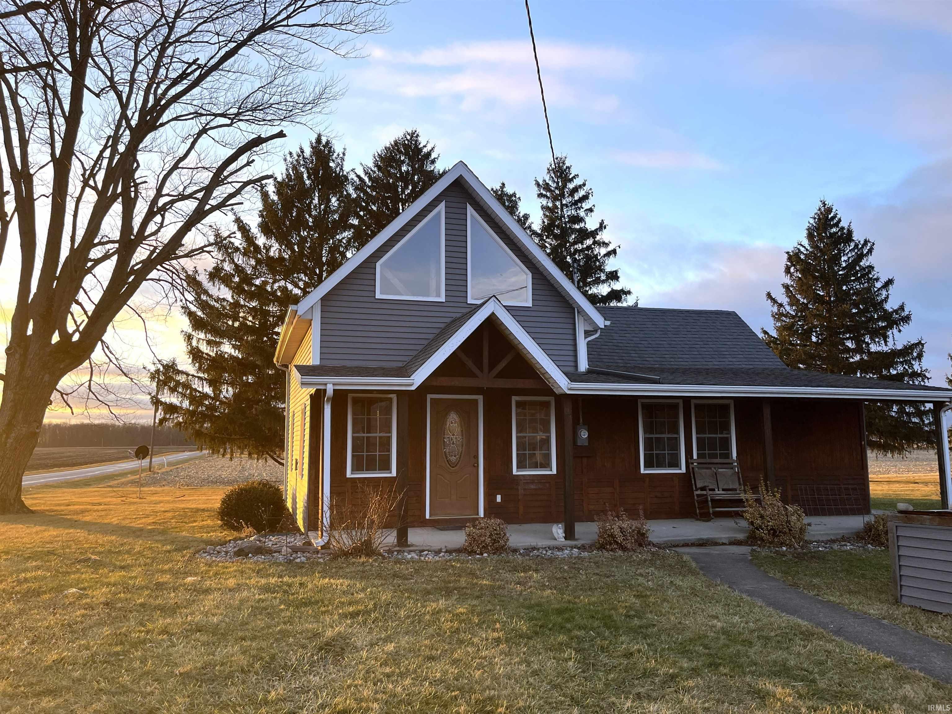 View of front of home with a yard and a porch