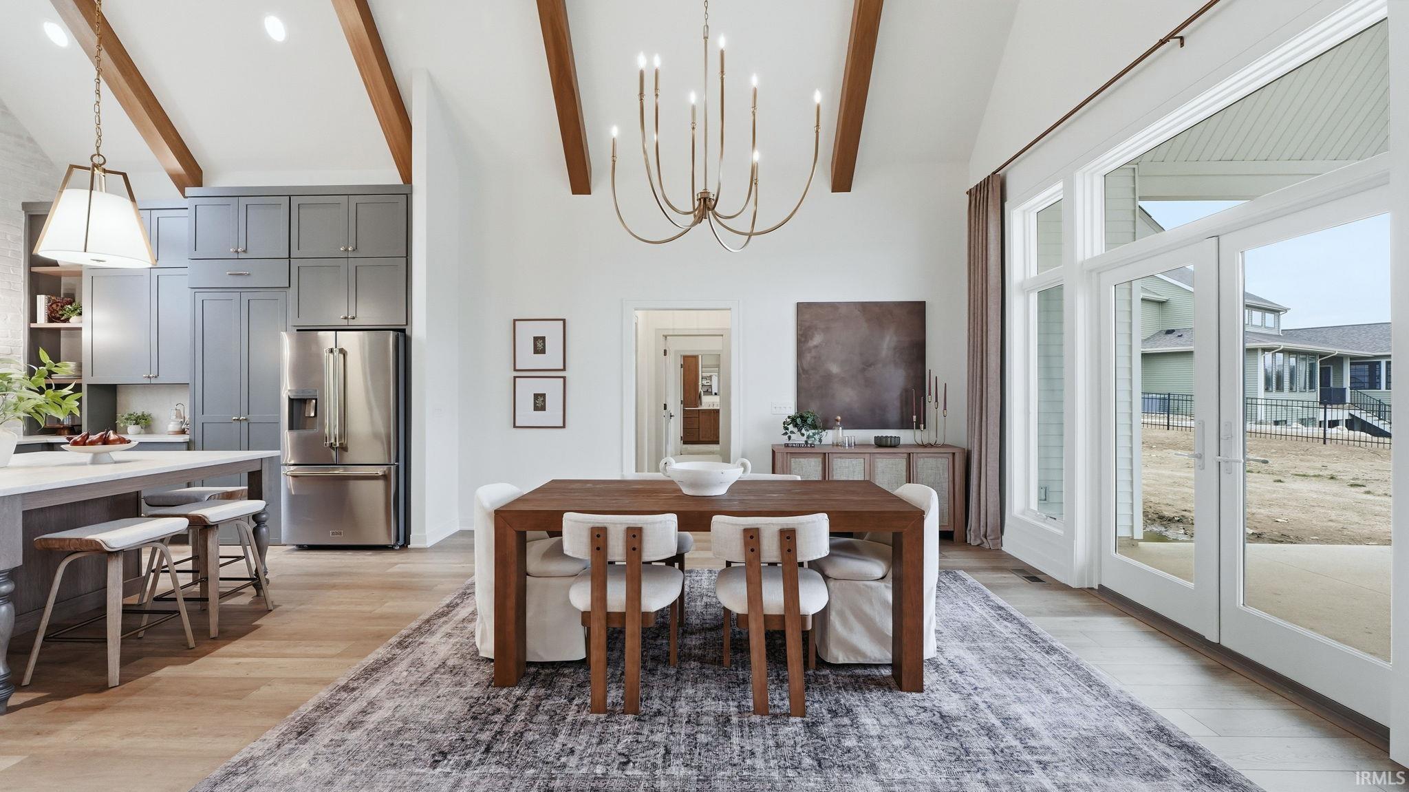 Dining room featuring suspended lighting, light wood-style flooring, and lofted ceiling