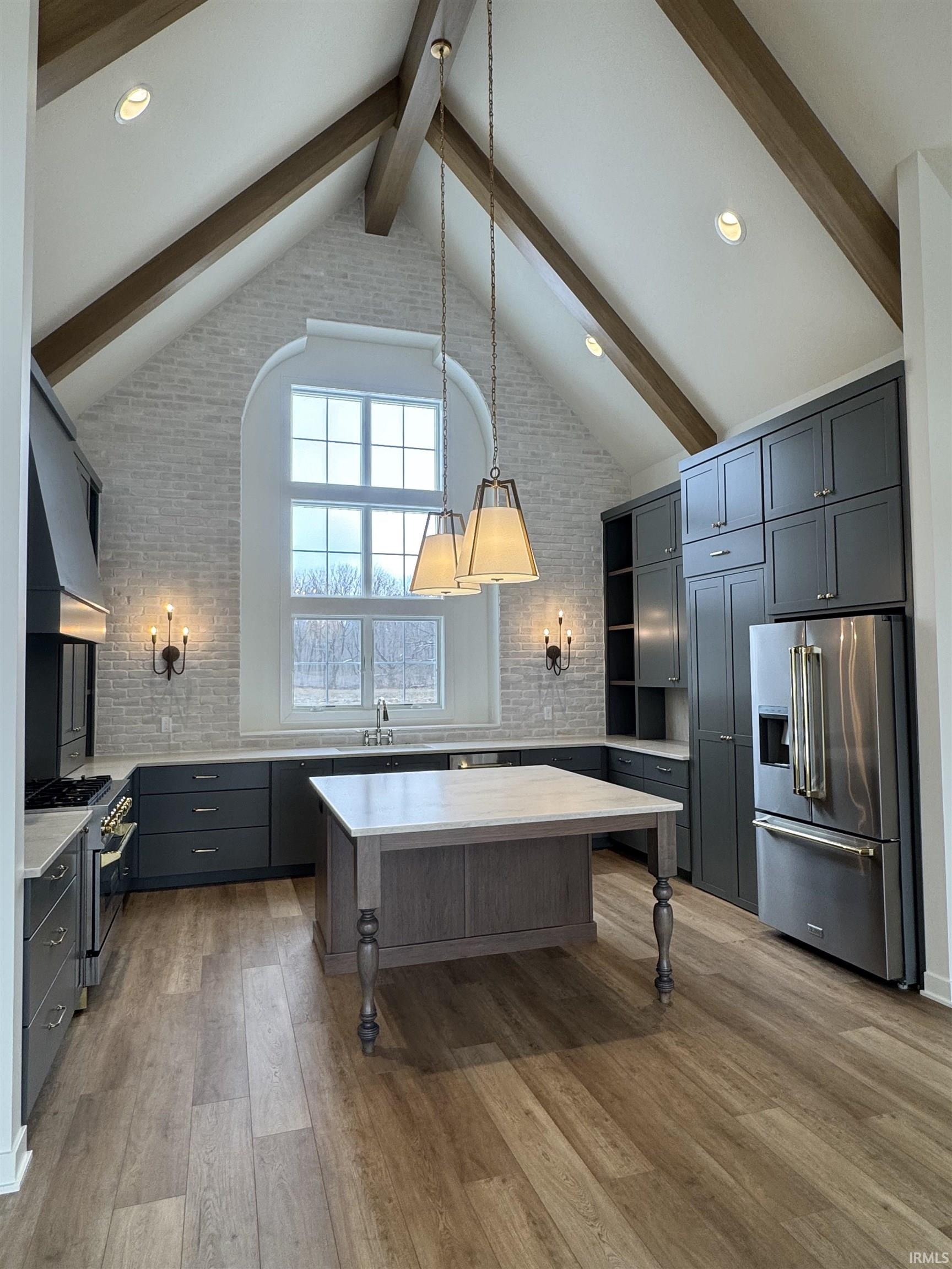 Kitchen with high quality appliances, a kitchen bar, light wood finished floors, a center island, and decorative backsplash