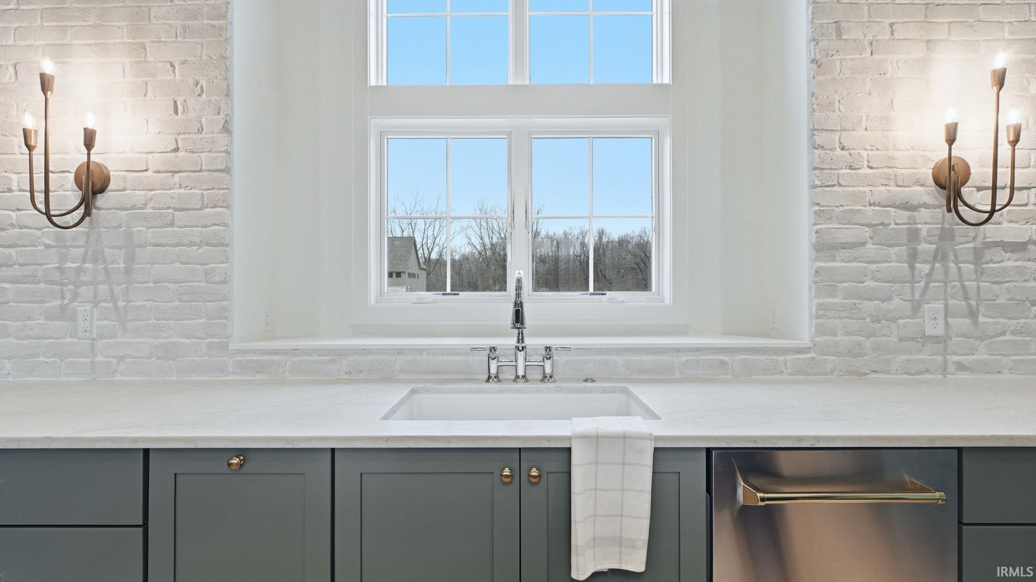 Bathroom with brick wall, vanity, and suspended lighting