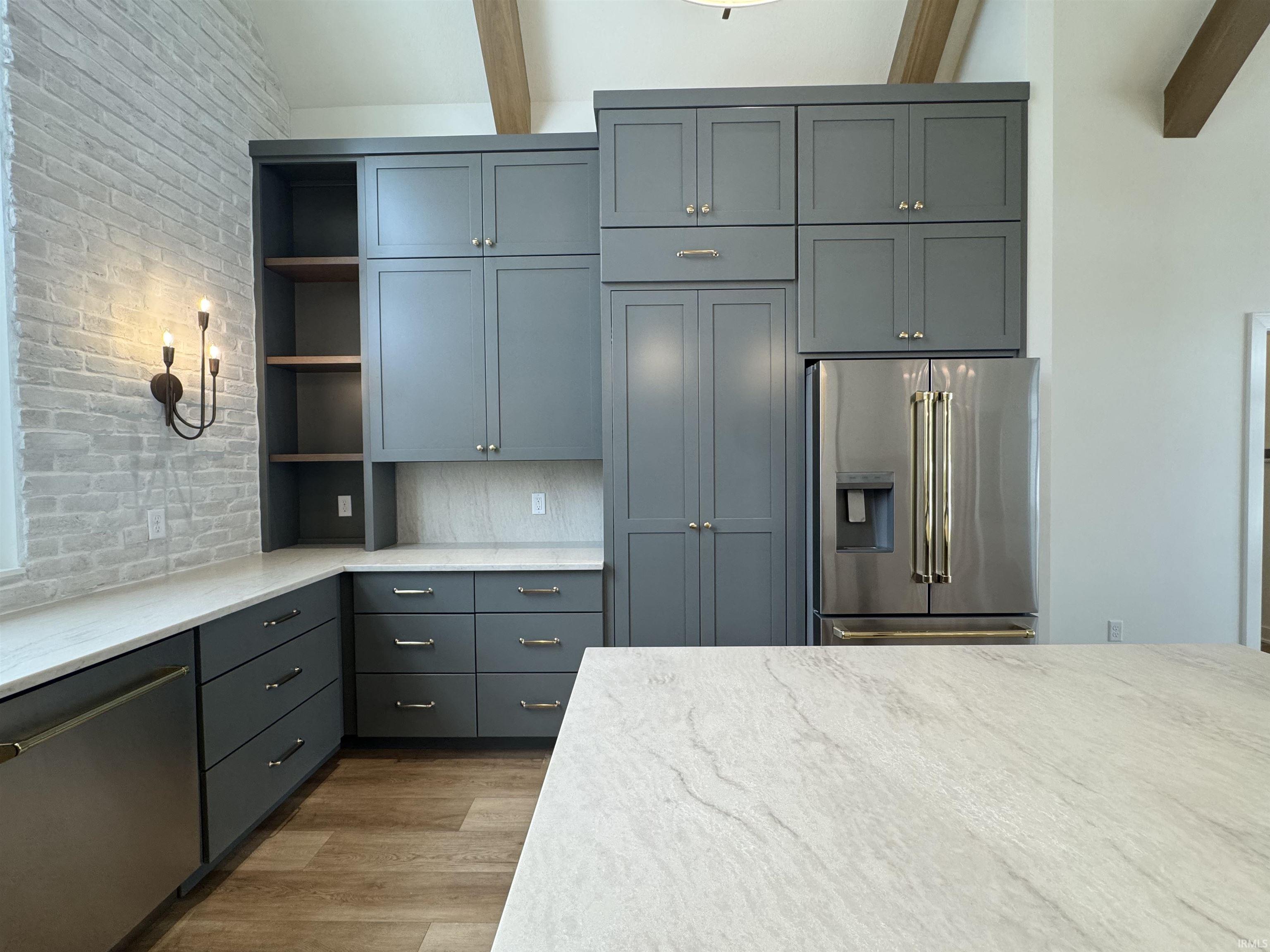 Kitchen with open shelves, stainless steel appliances, gray cabinetry, light wood-type flooring, and light stone counters