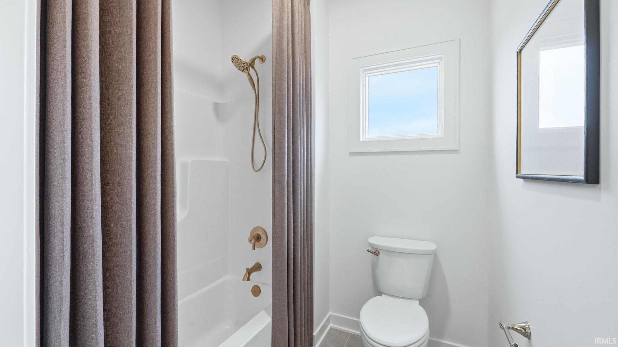 Full bathroom with shower / bathtub combination with curtain and toilet