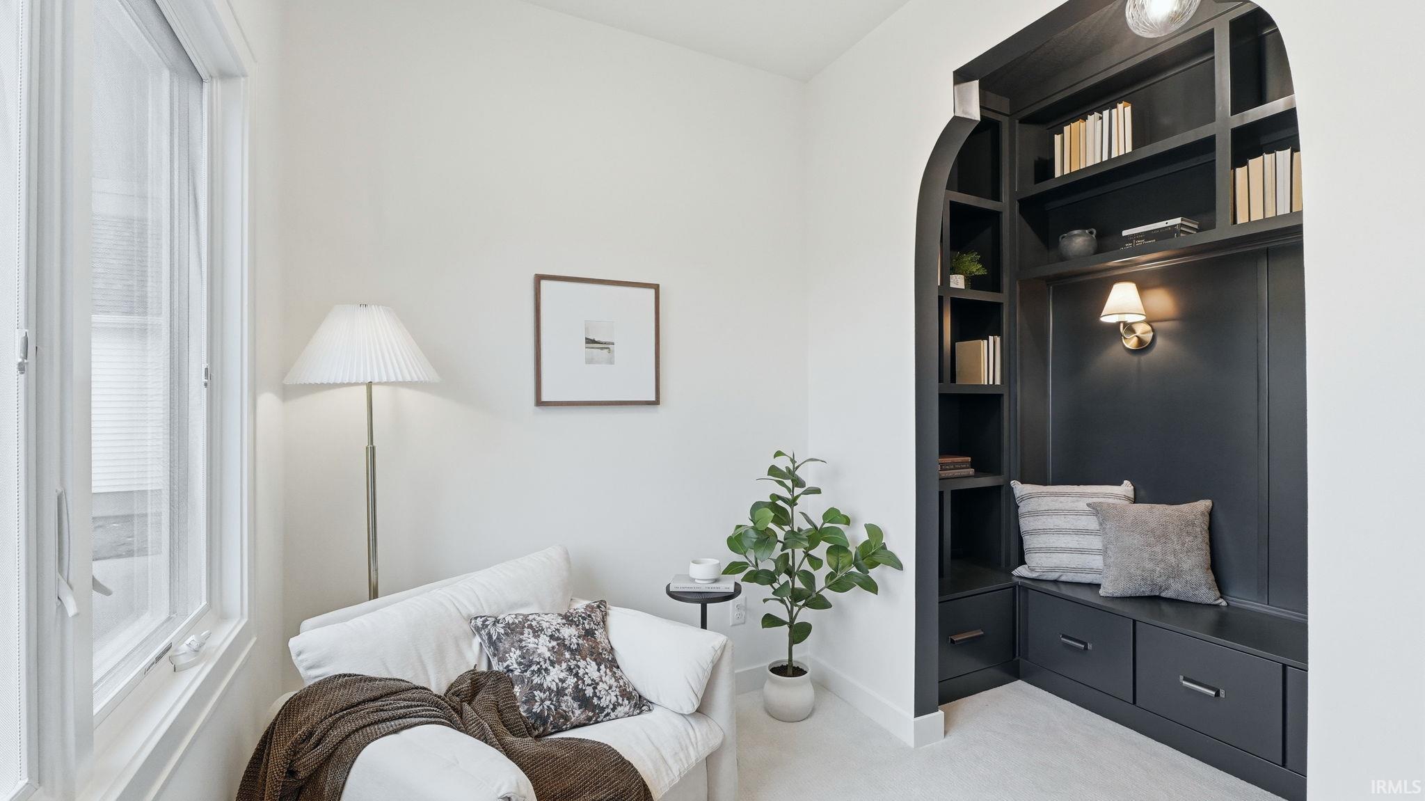 Living area with light carpet and baseboards