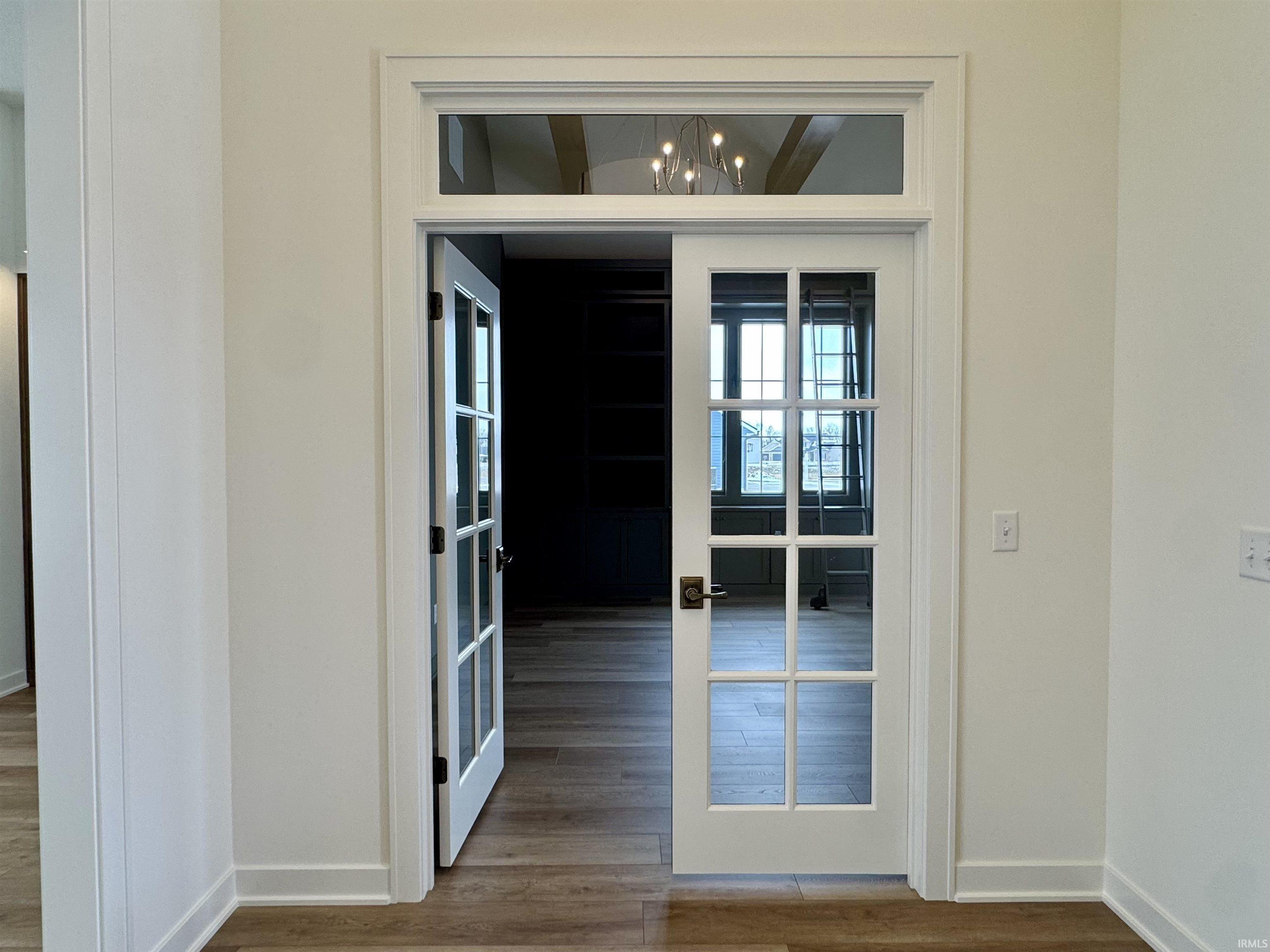 Doorway featuring wood finished floors, french doors, and suspended lighting