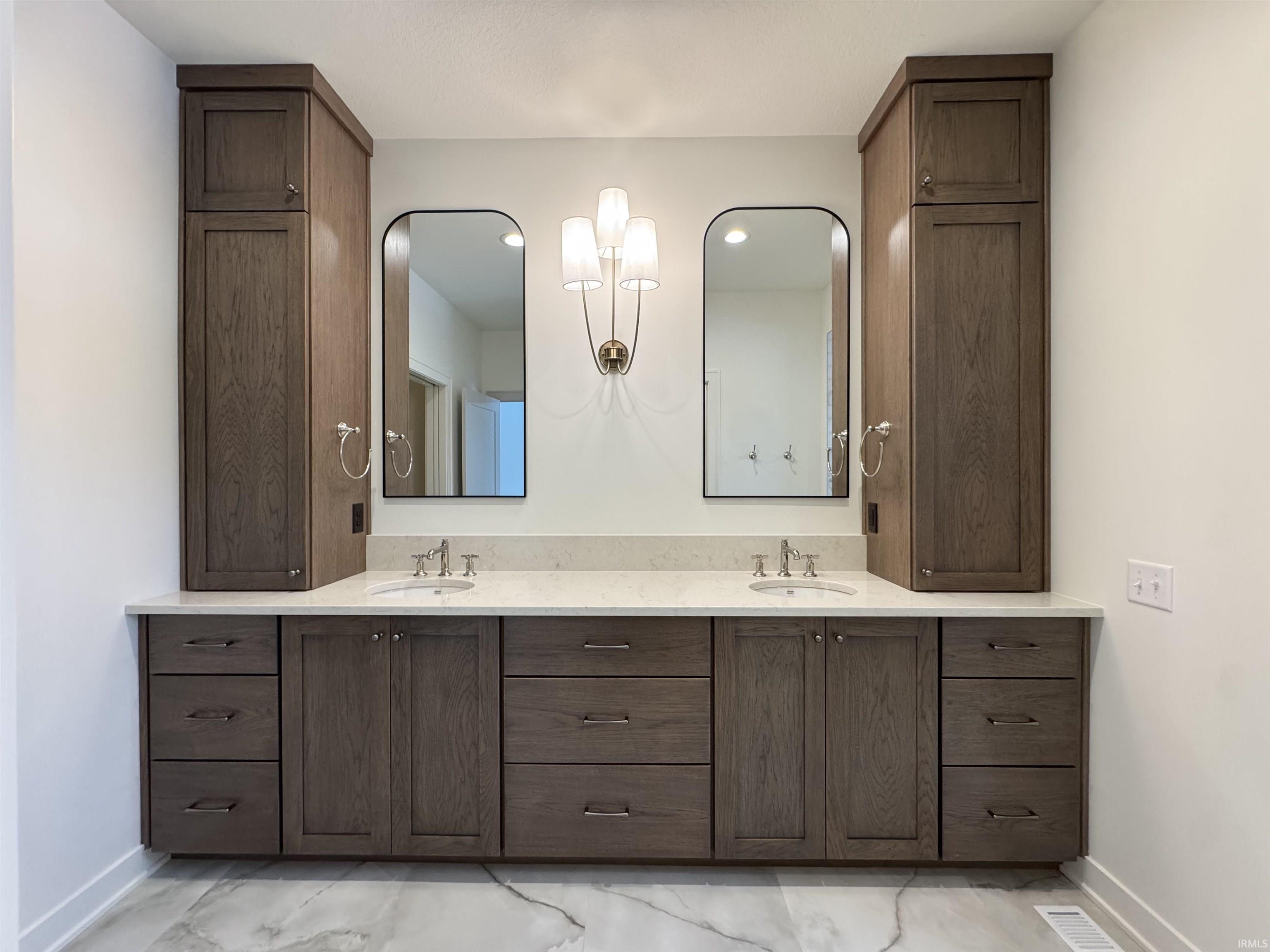 Full bath with double vanity and baseboards