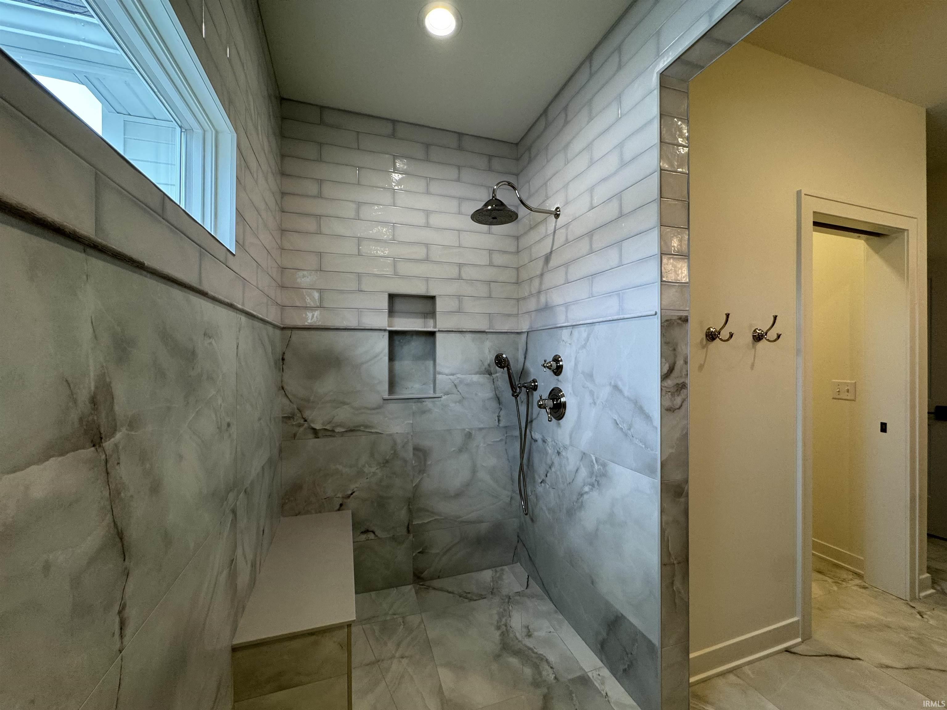 Bathroom featuring a marble finish shower and baseboards